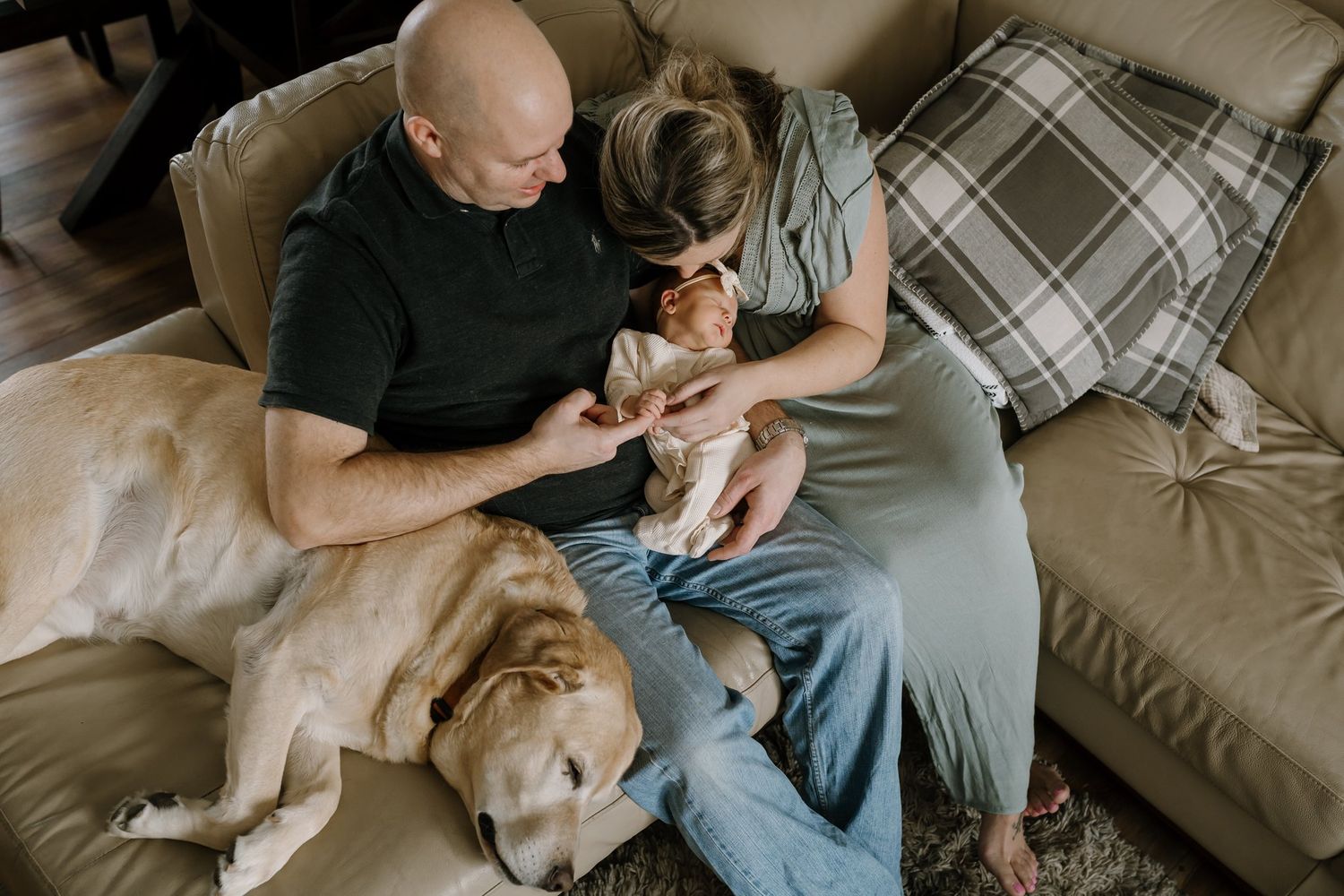 mom and dad snuggle newborn baby during lifestyle newborn photos