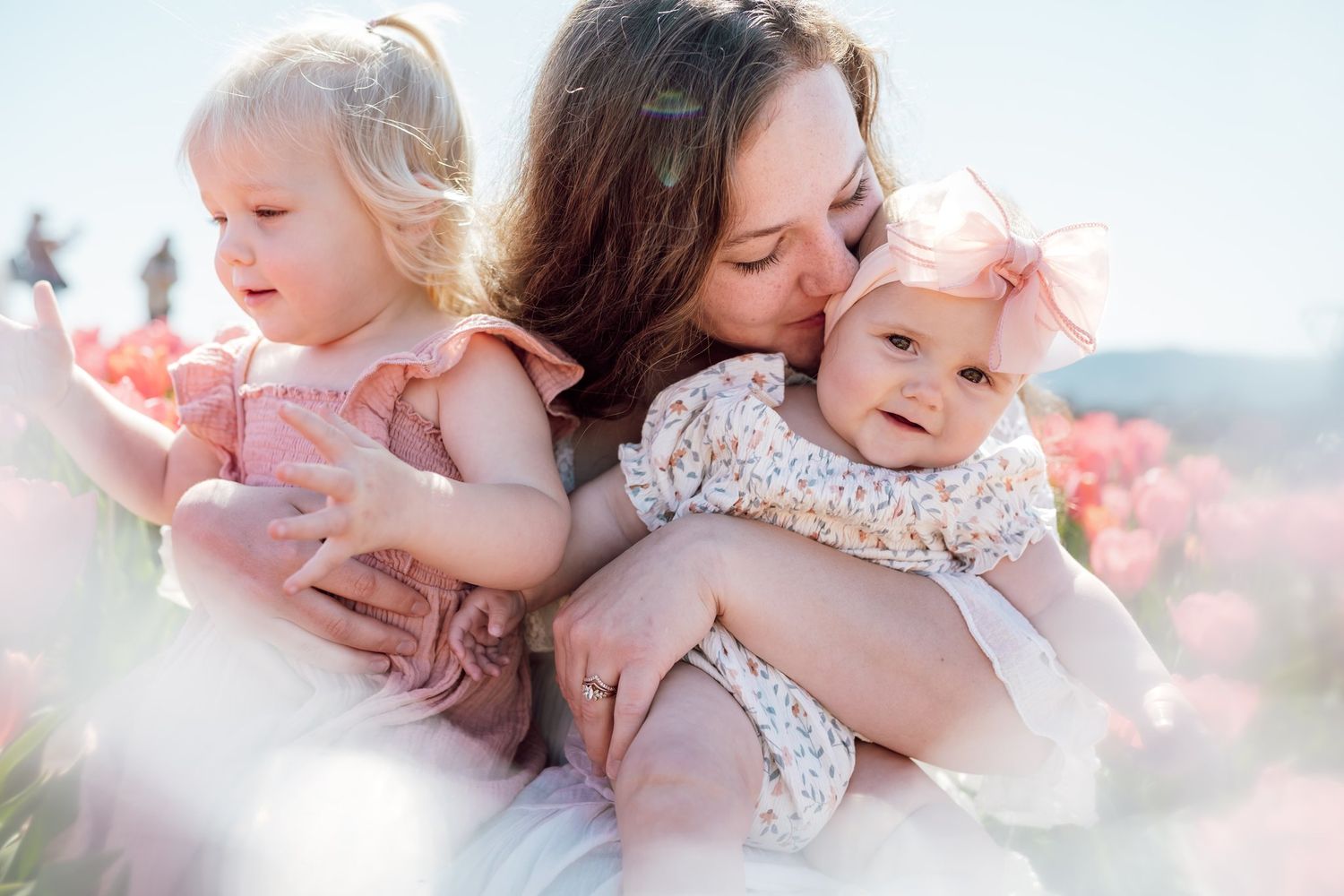 Mom snuggles her toddlers during motherhood flower field photography session near knoxville