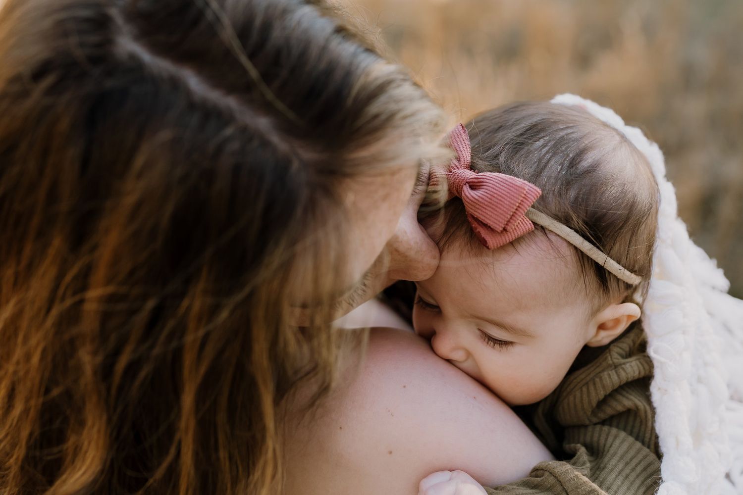 Mom kisses daughter during family pictures in great smokies