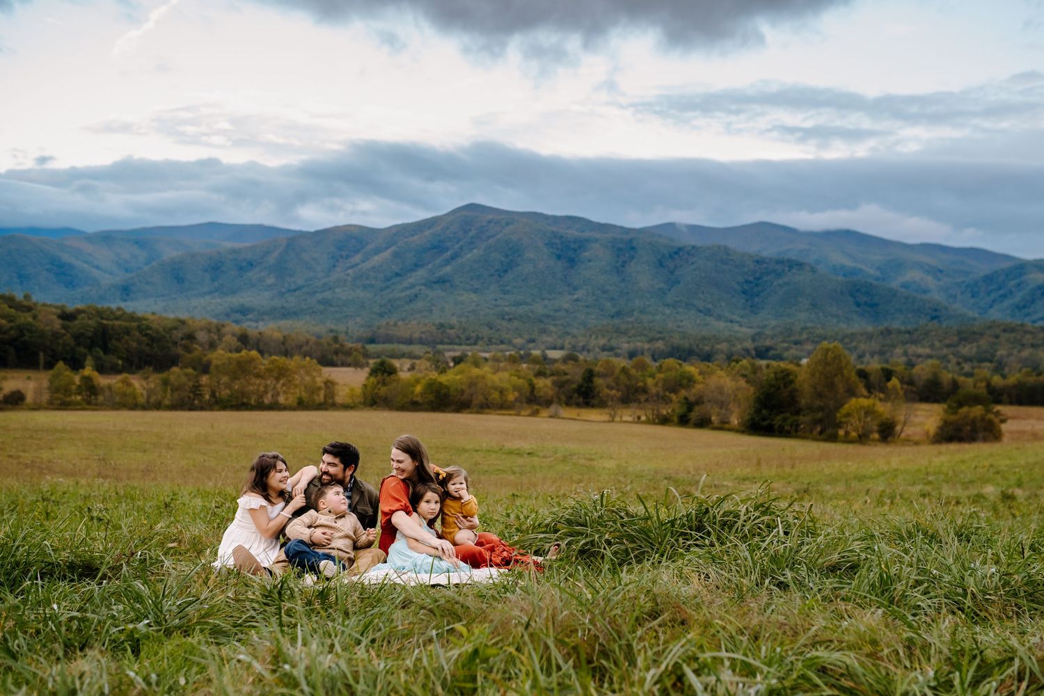 Family sits in Cades Cove and snuggles together