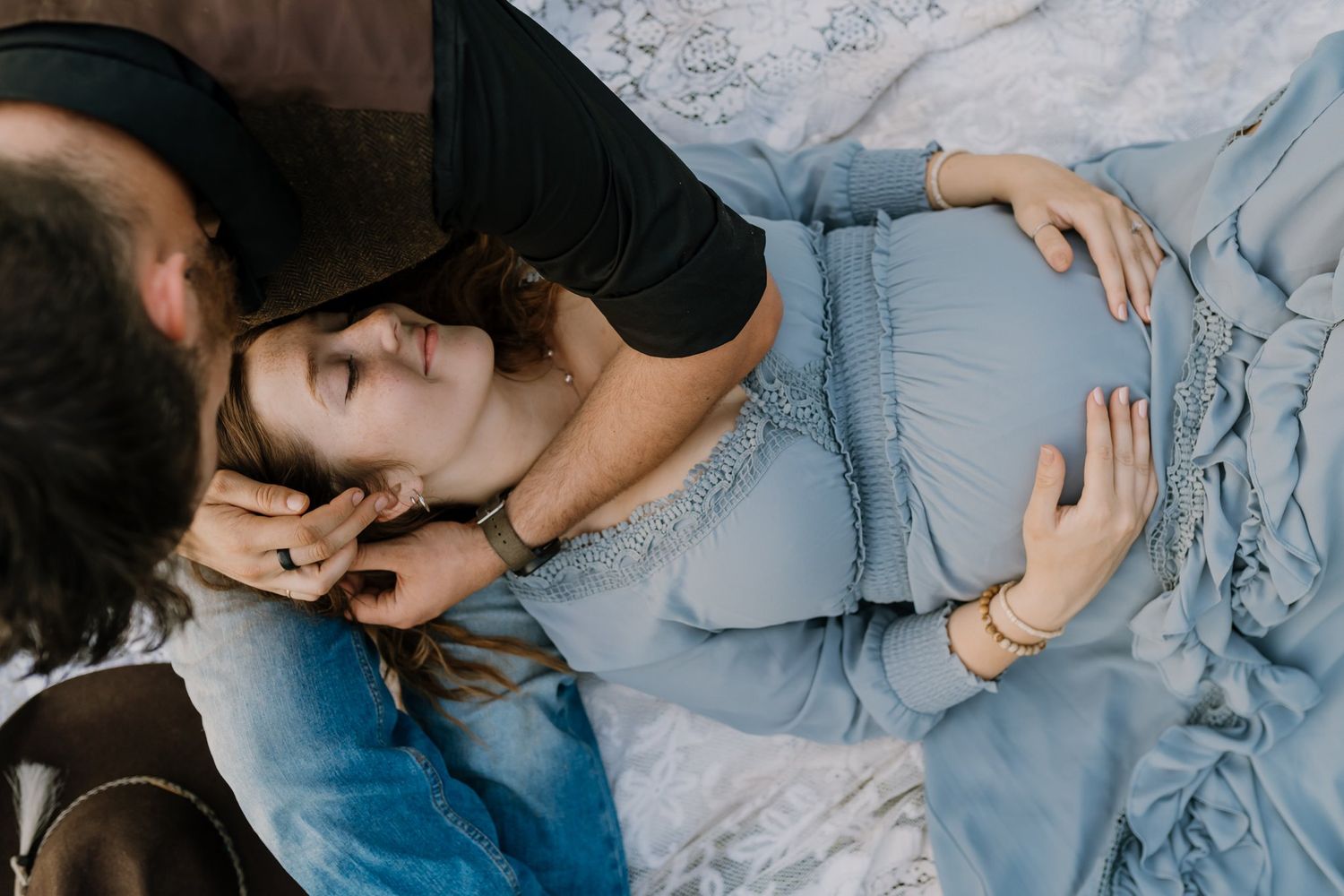 Pregnant mom lays on husband's lap and smiles during West Knox Maternity Photography session