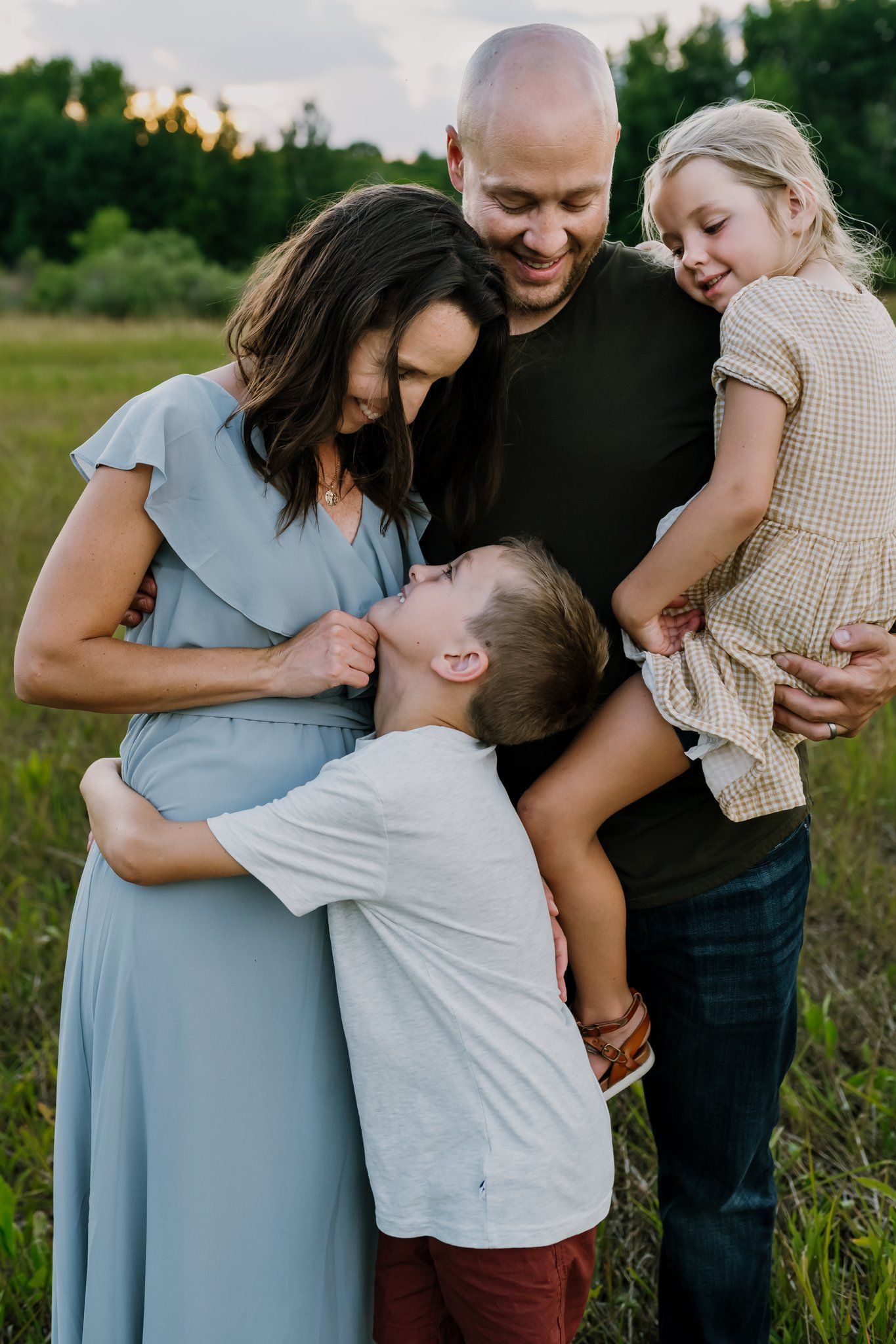 Family of four laughs together during playful family pictures