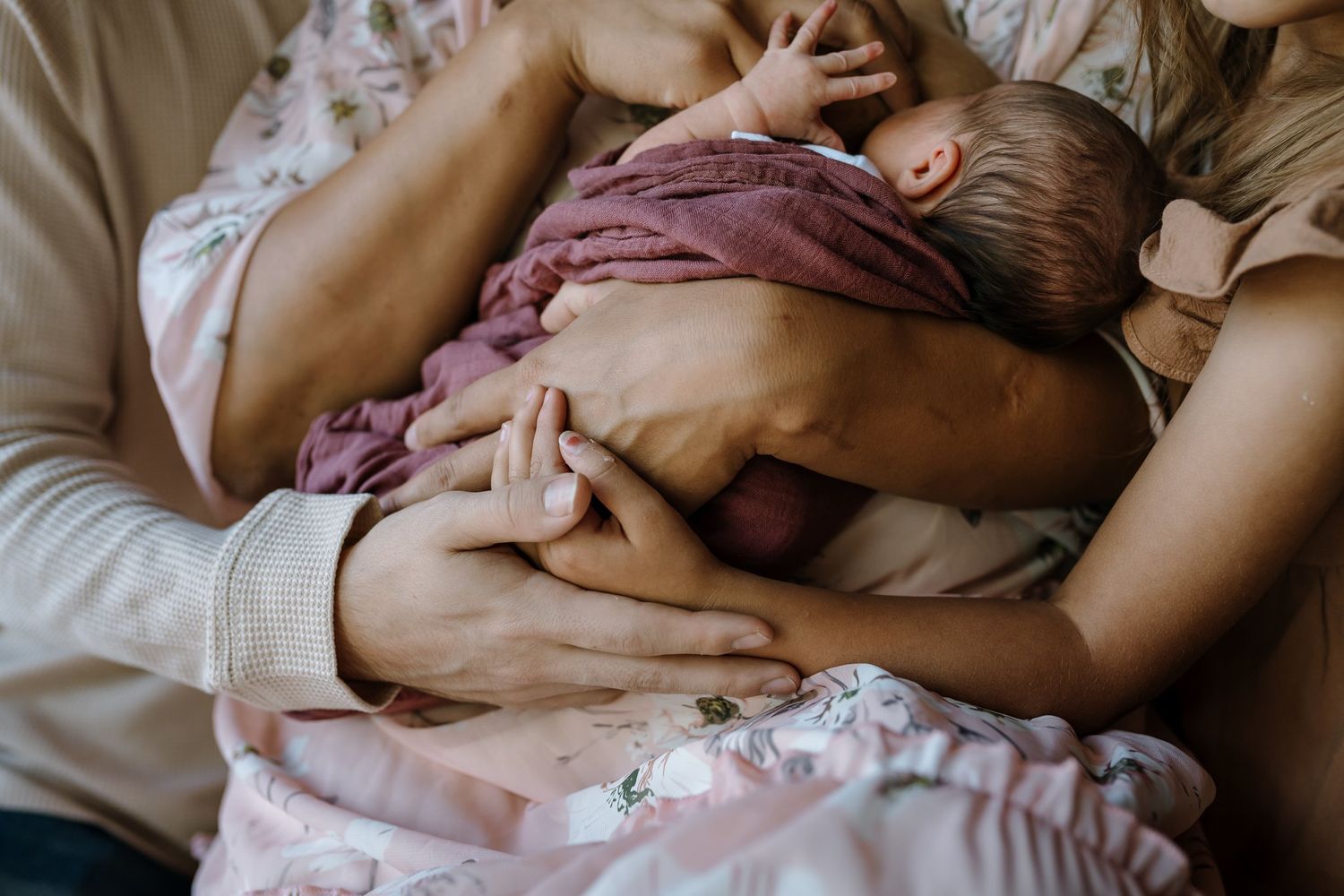 Family embraces while mom nurses baby