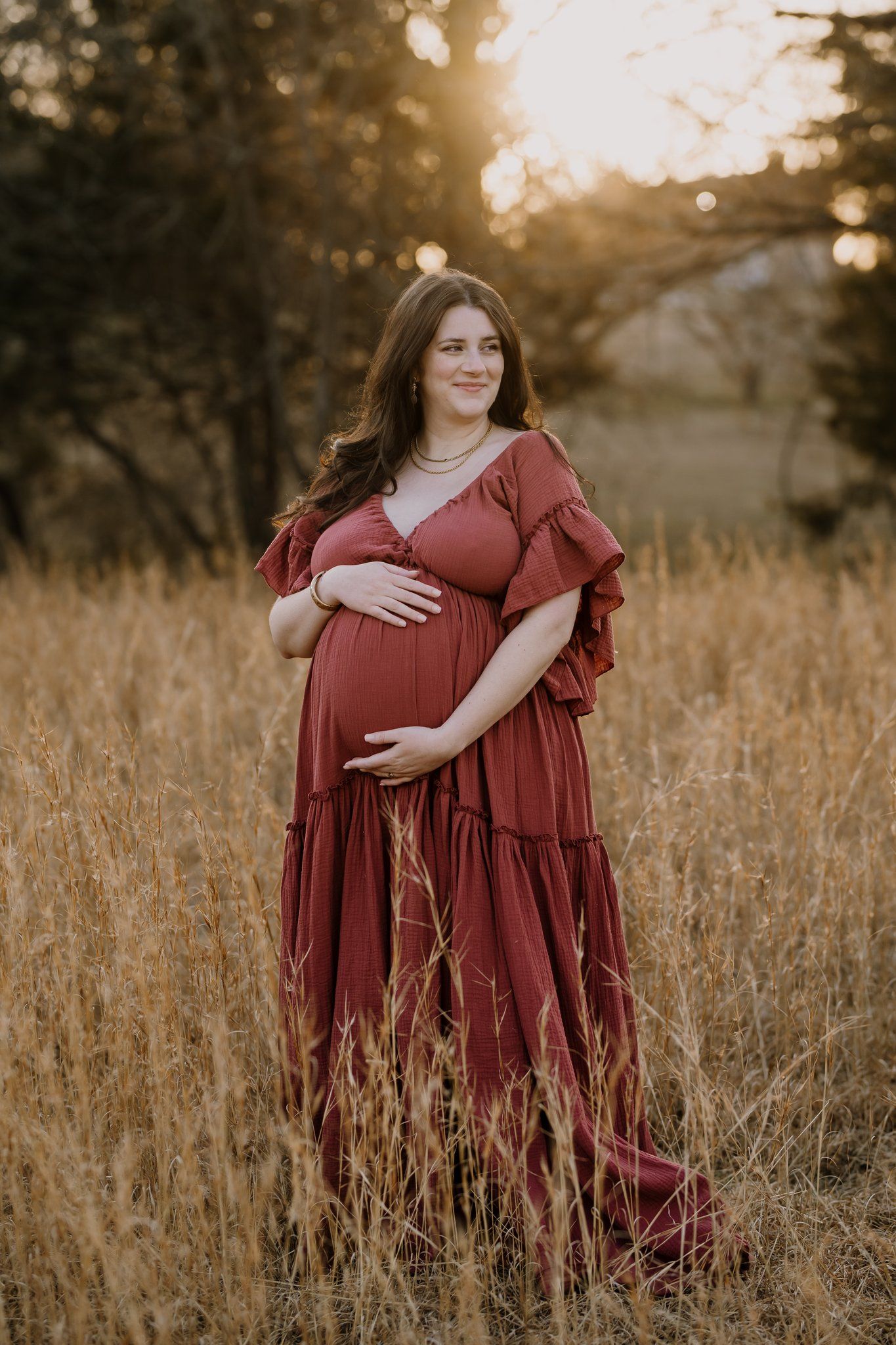 Pregnant mom holds her belly during pregnancy pictures at the holmstead studio in knoxville tn