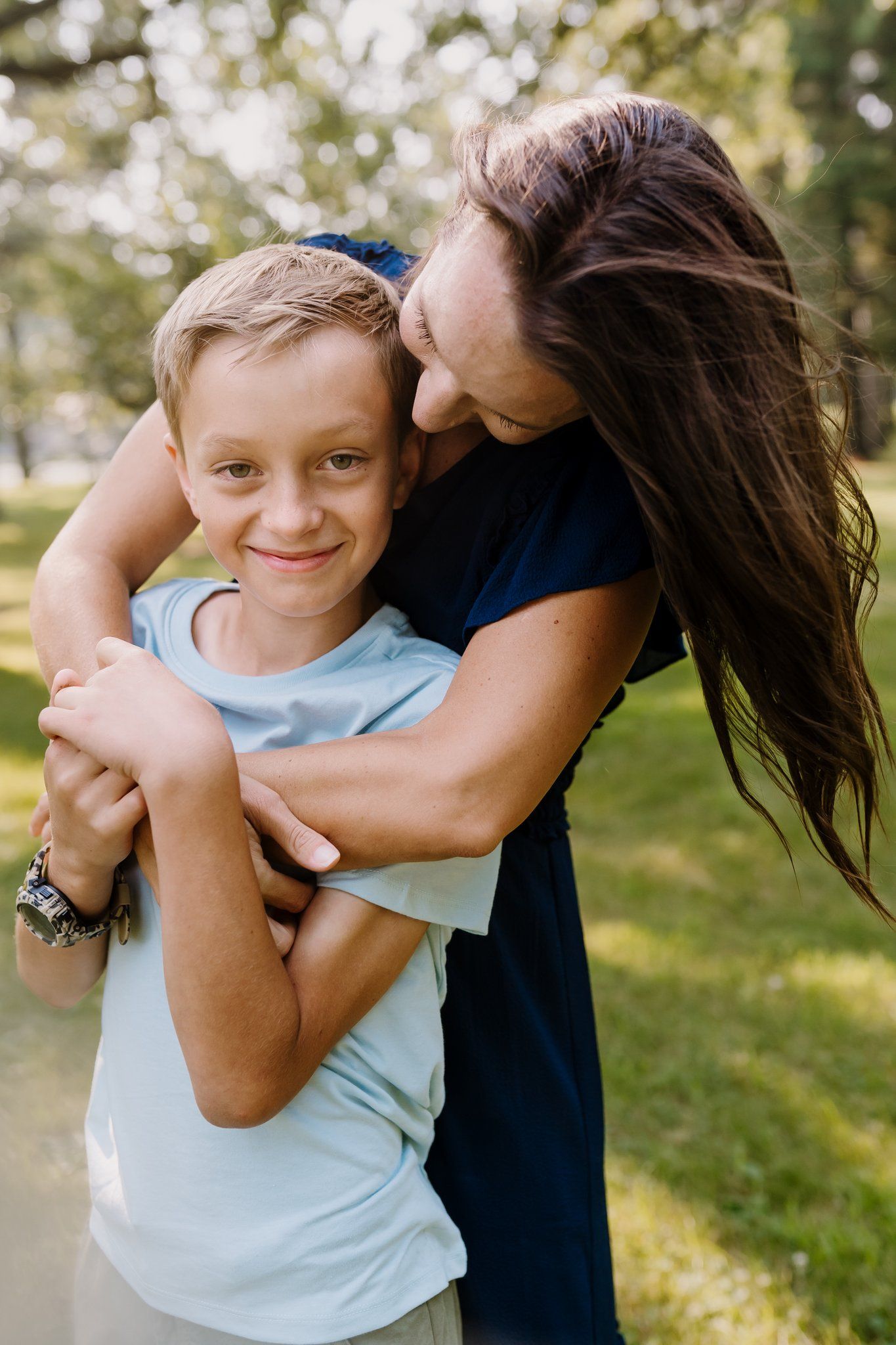 Woman embraces her son during family photos