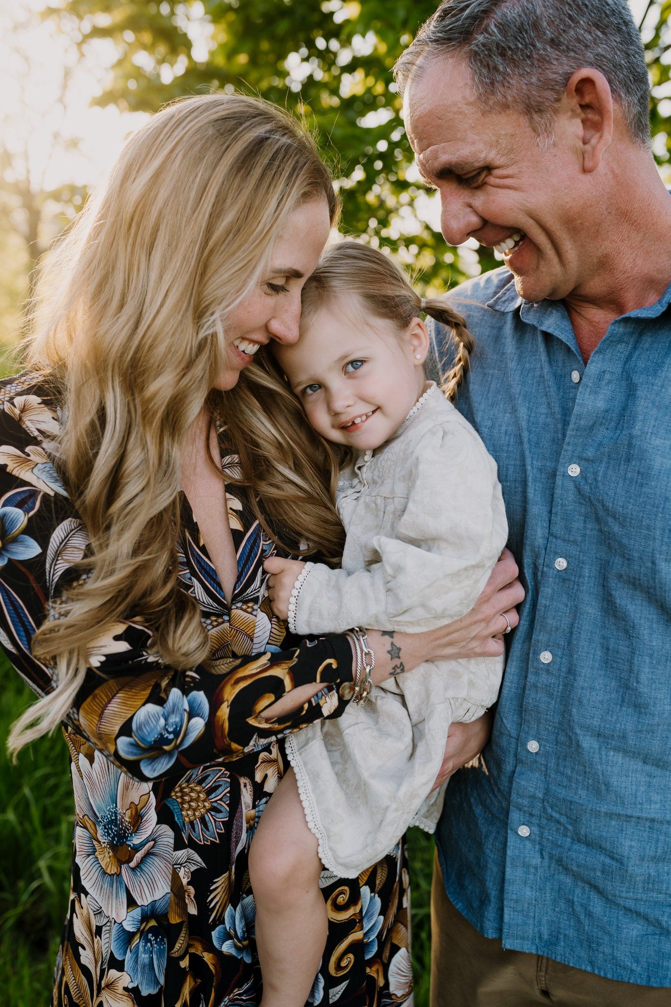 Mom and dad snuggle their toddler