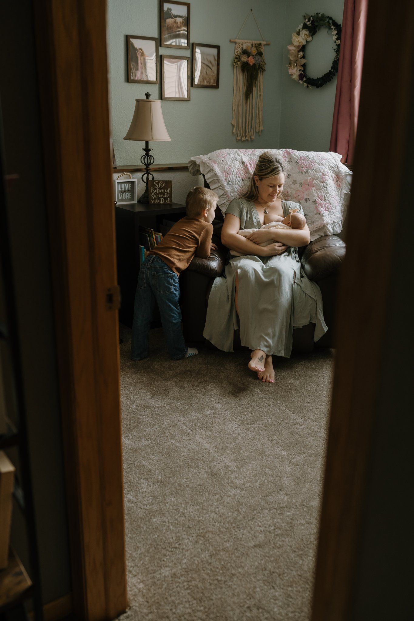 Mom nursing newborn while older brother watches during in home baby photos lifestyle newborn photographer knoxville tn