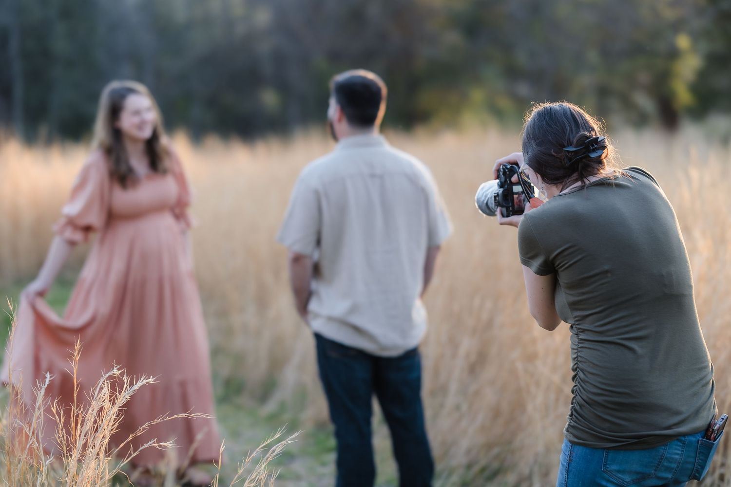 Woman photographs a couple during maternity photos
