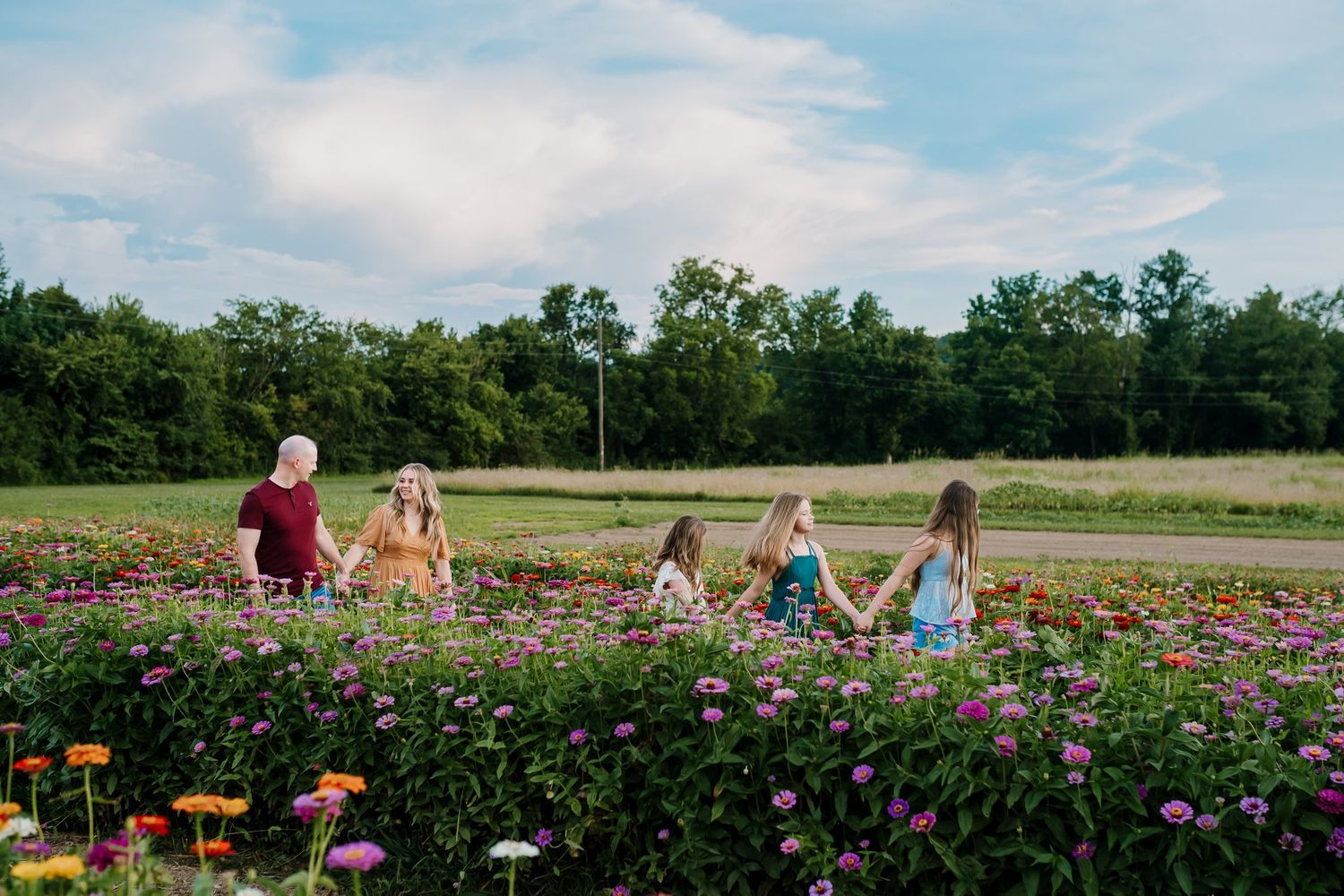 Family walks through a u pick flower field during family photos