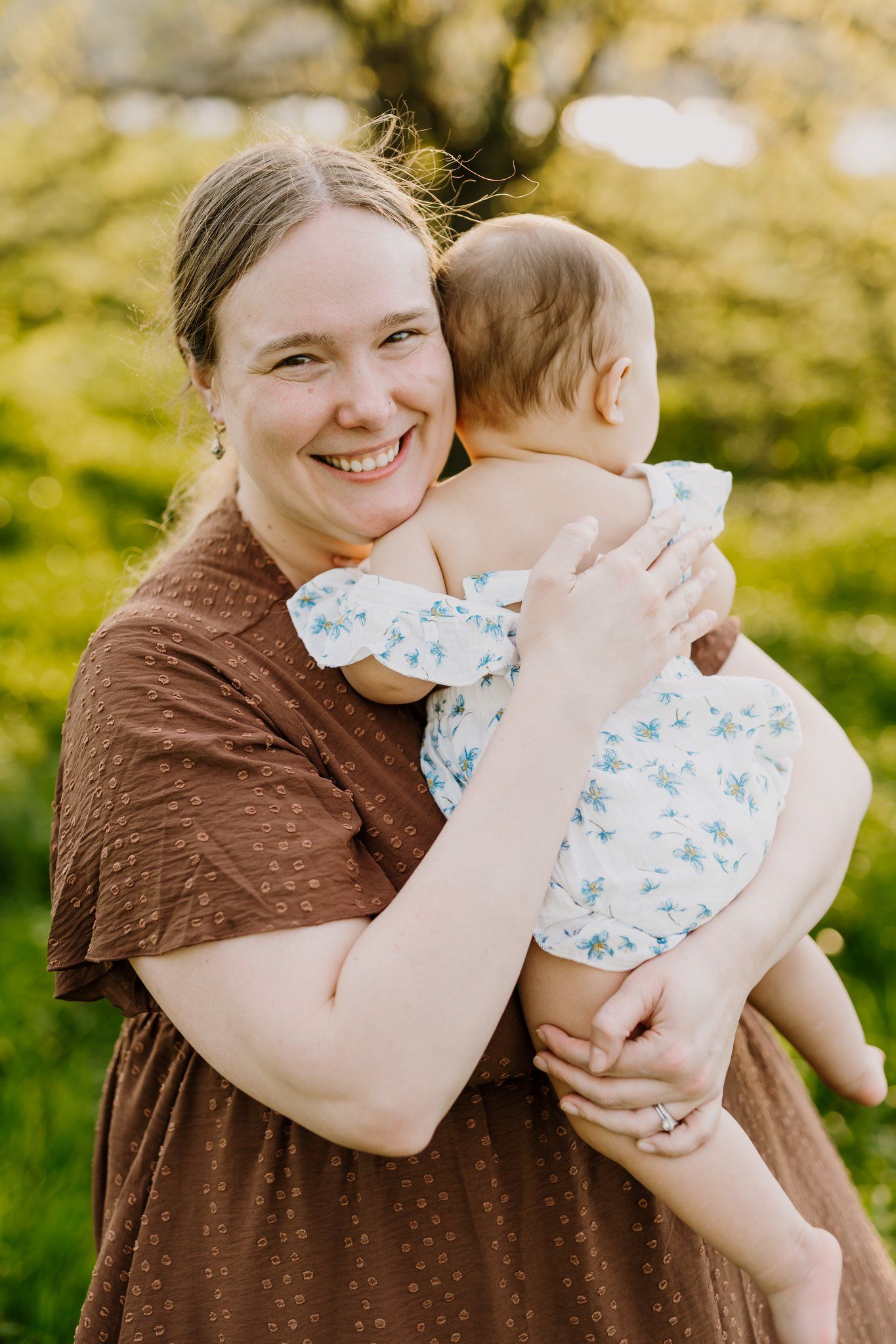 Mom smiles at camera while holding her baby
