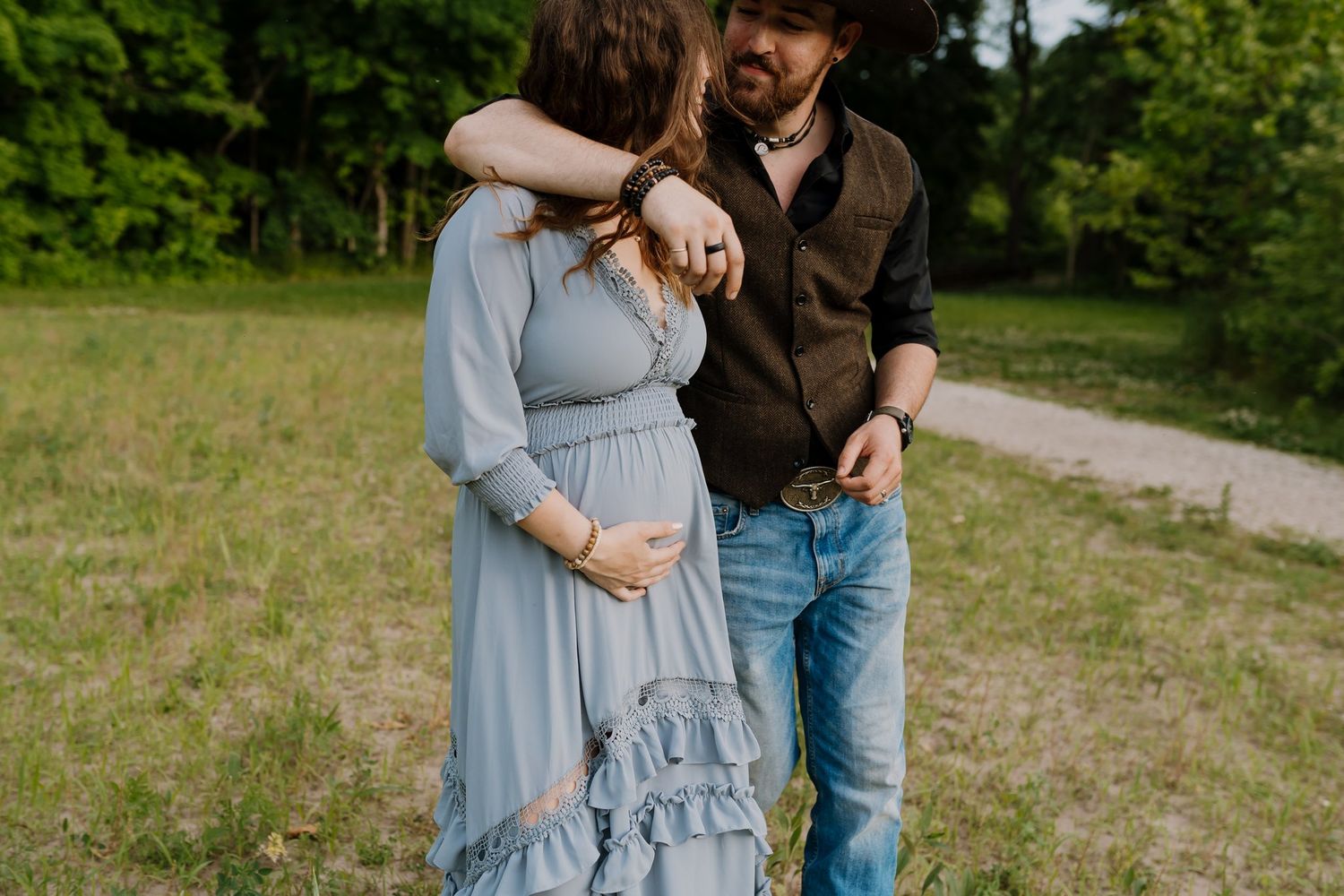 Husband and wife walk through field during family maternity session Maryville Maternity Photography Session