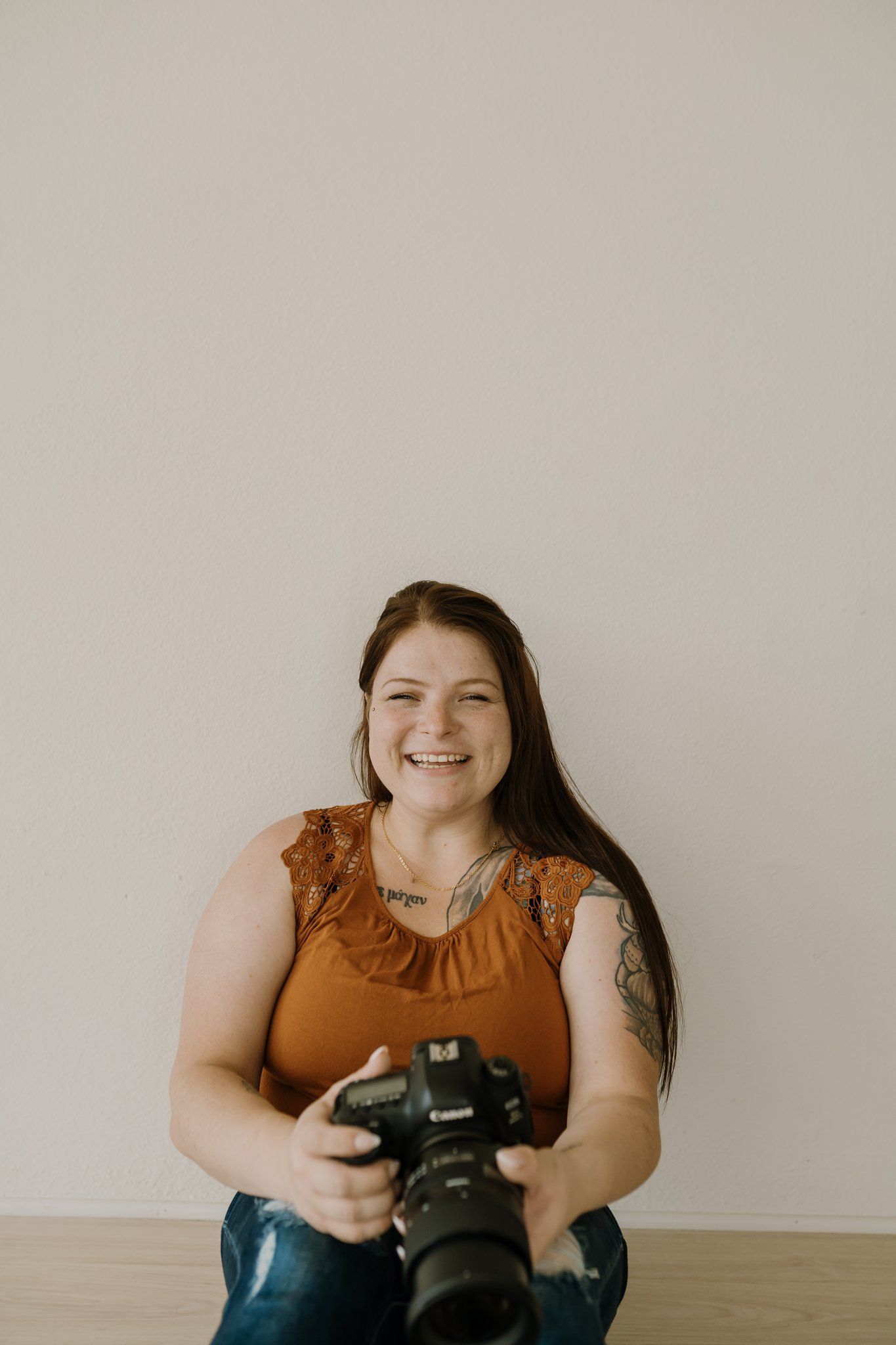 Woman holds her camera and laughs