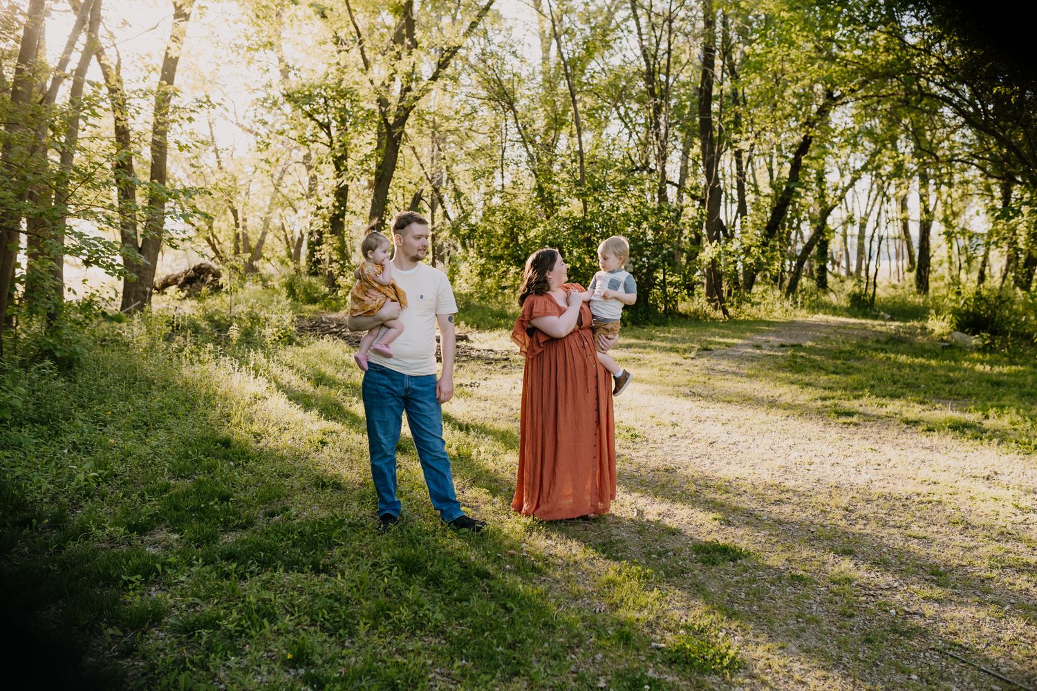 Family stands in park at golden hour