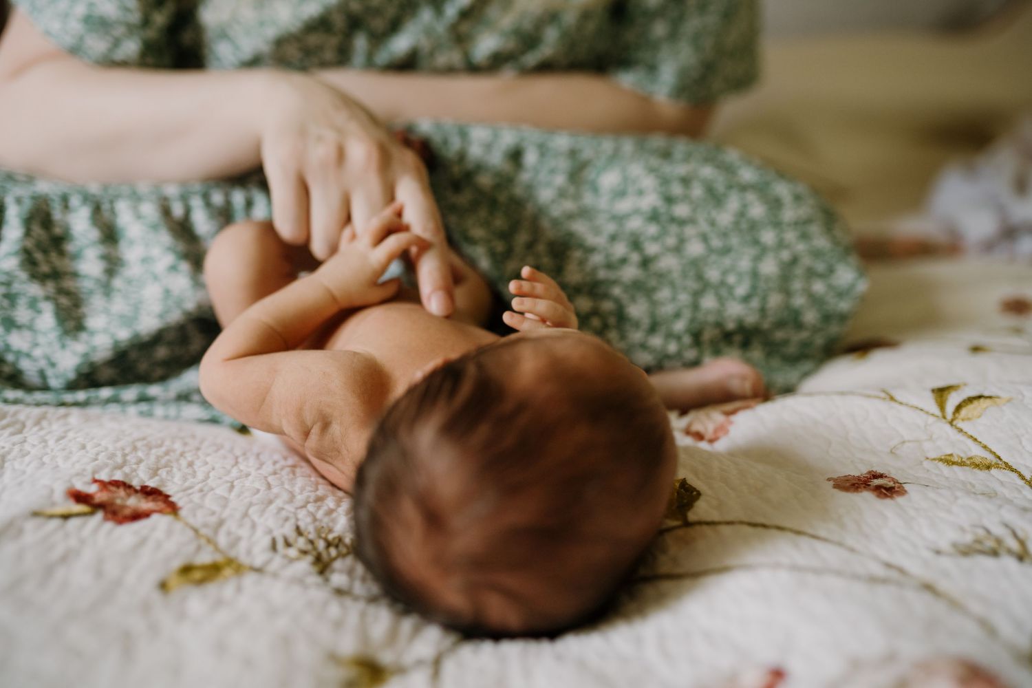 Mom plays with baby during newborn photos