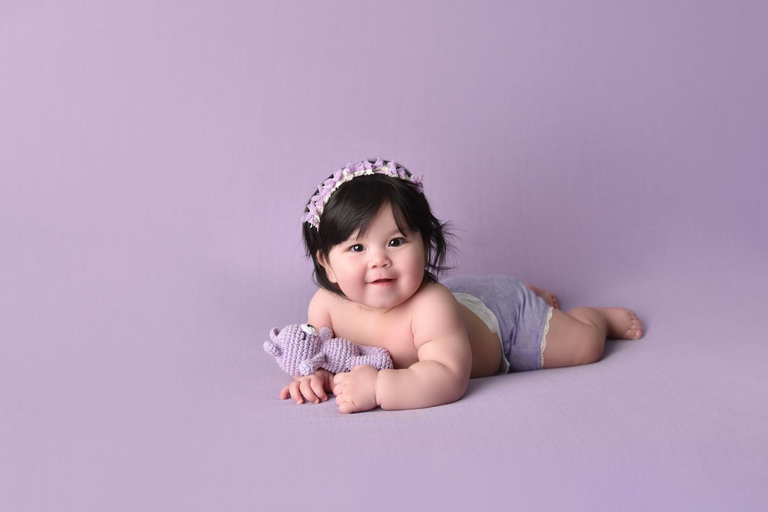 Purple studio backdrop setup for infant photography session.