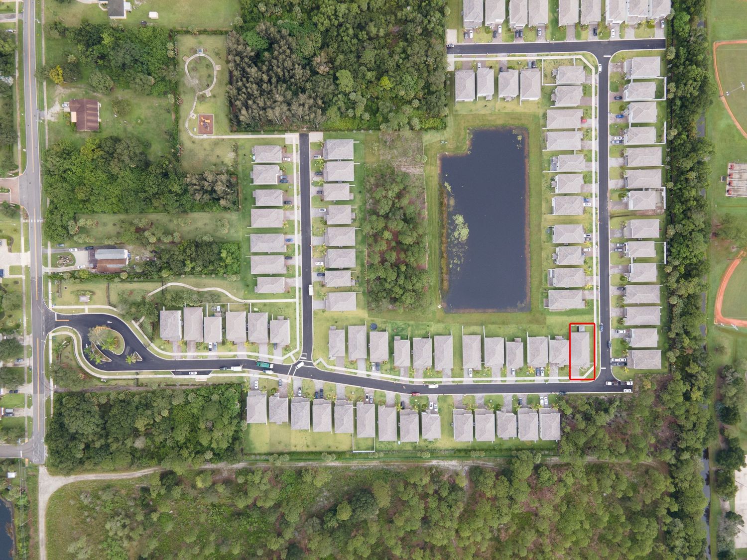 Aerial view of residential mobile home community with central pond.