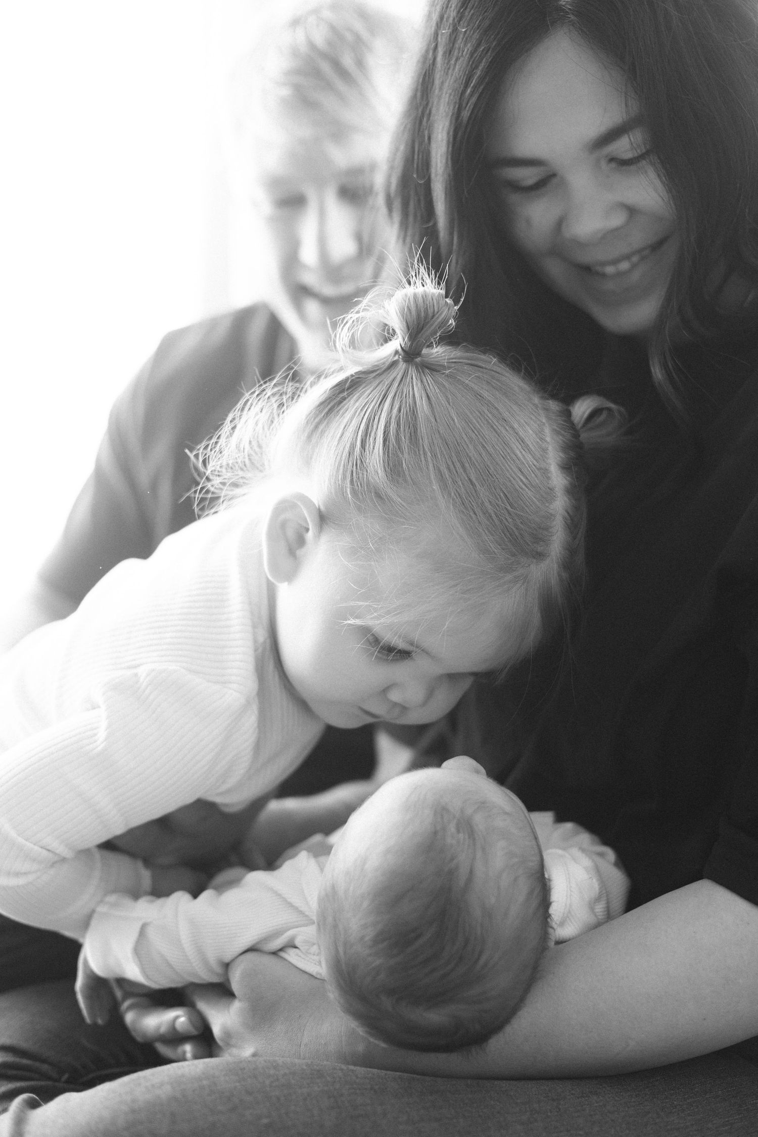 A touching black and white photo series showing tender moments between family members sharing affectionate embraces.
