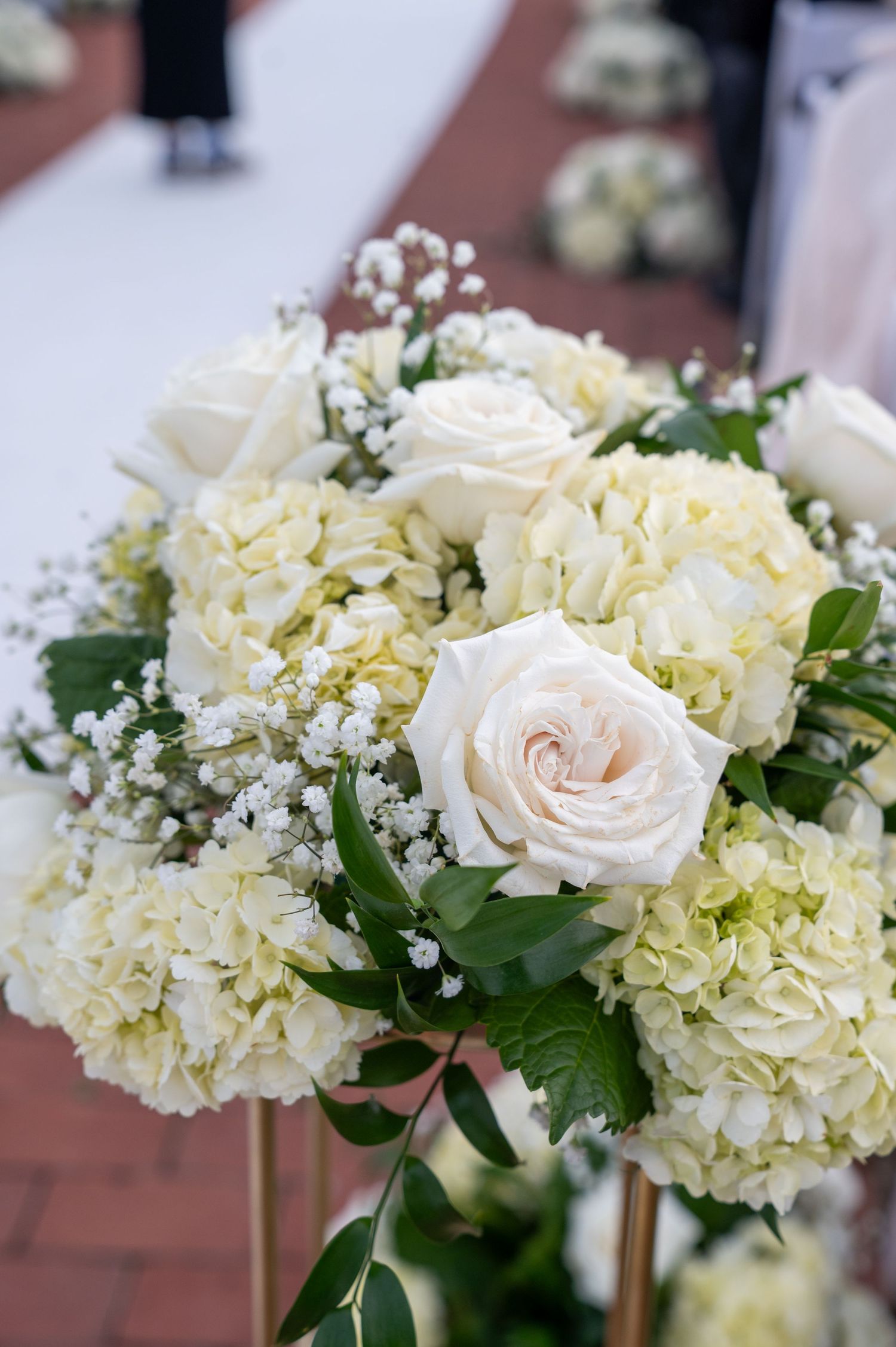 Close-up view of elegant white hydrangeas and pale pink roses with baby's breath in a floral arrangement.