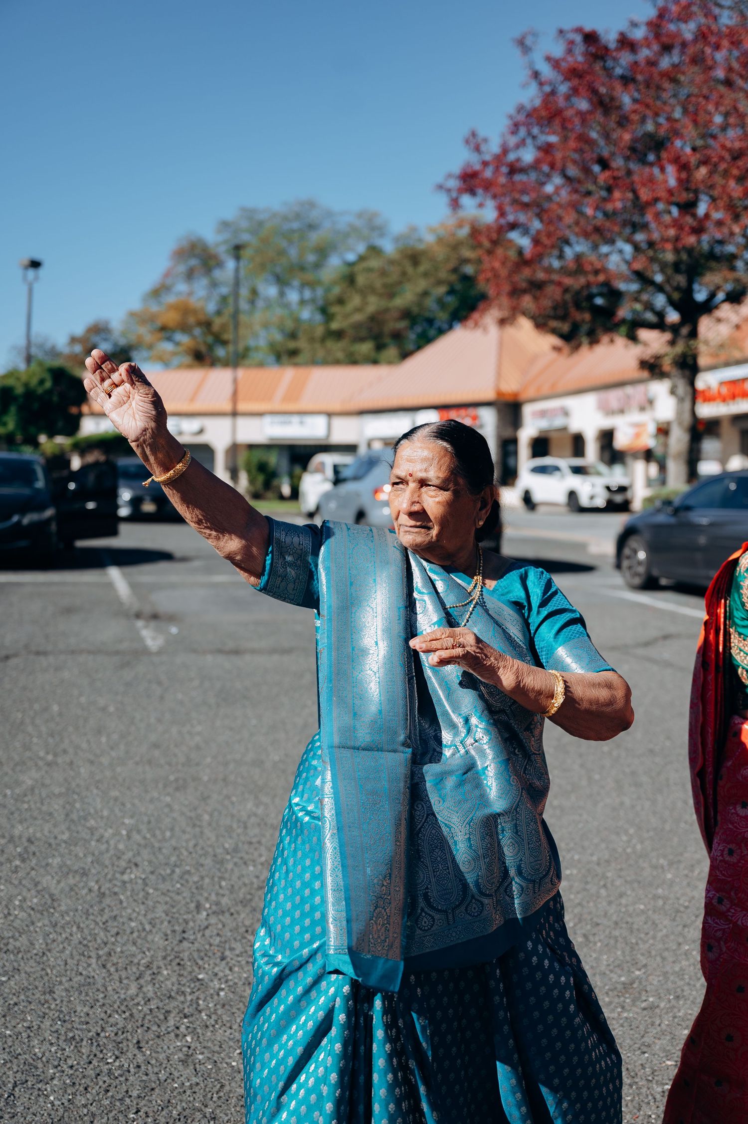 People in bright blue traditional outfits dancing or celebrating outdoors.