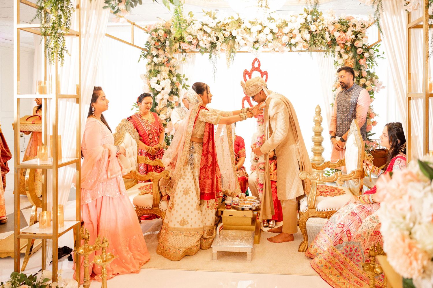 Elegant Indian wedding ceremony setup with pink and coral floral decorations and traditional mandap.