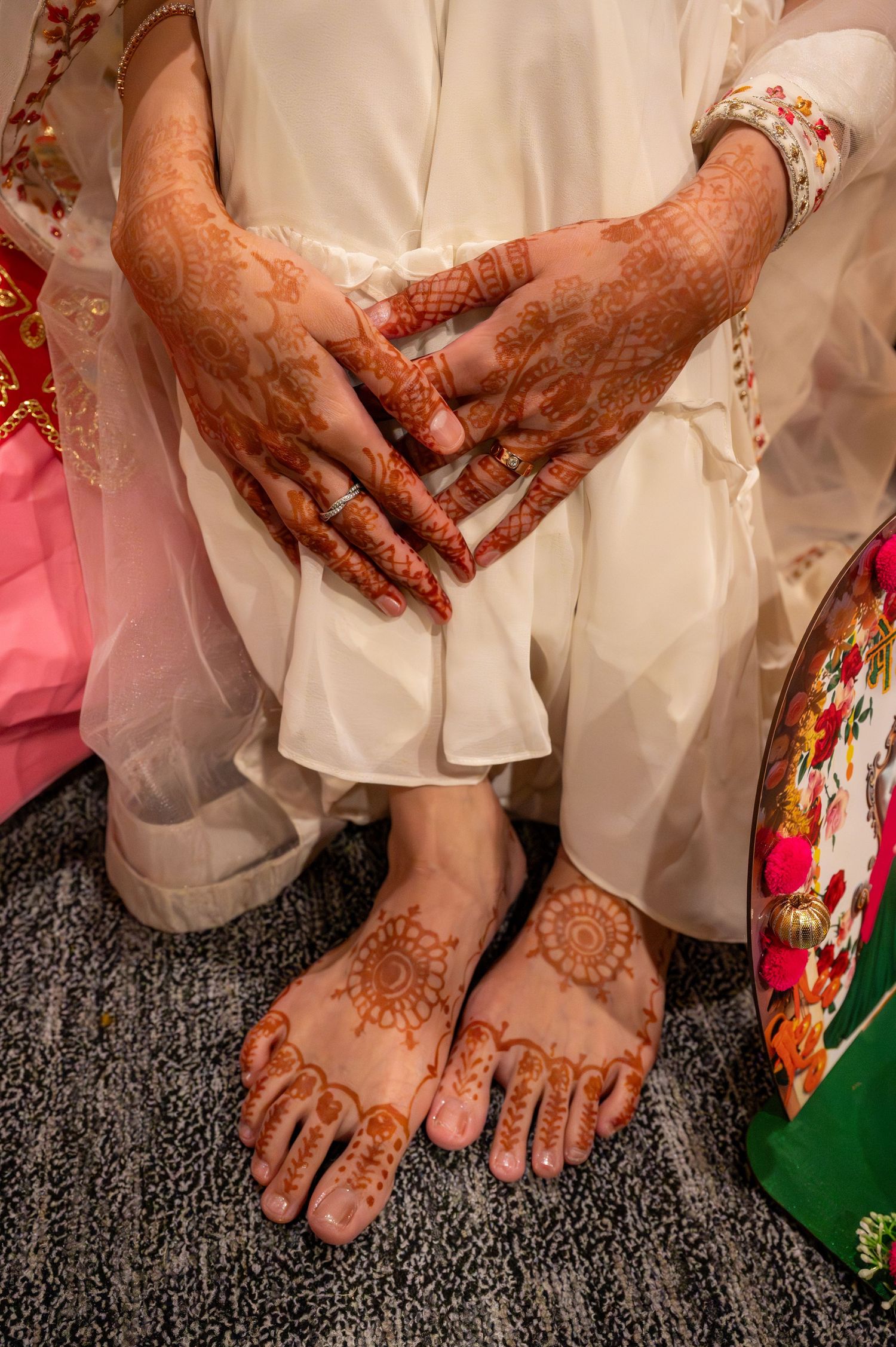 Close-up shots of hands and feet adorned with intricate henna designs during a traditional Indian wedding ceremony.