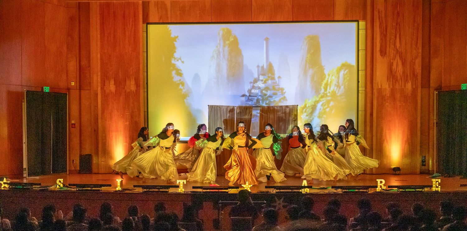 Wide stage performance with dramatic lighting and projections.