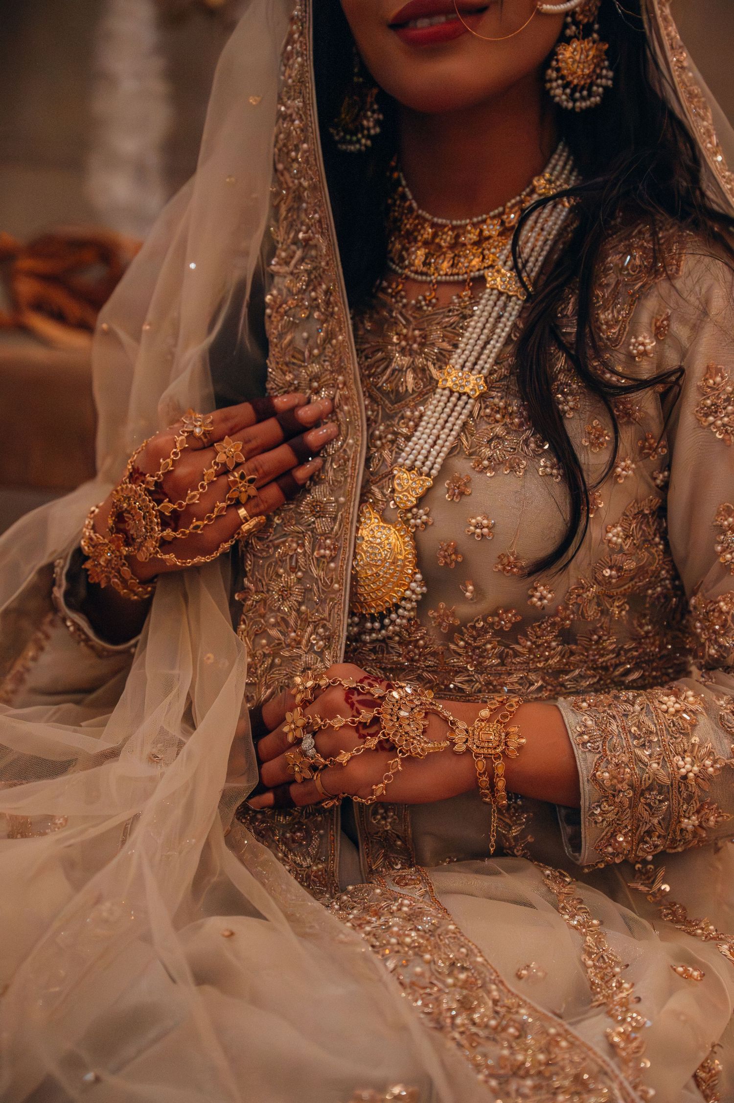 Close-up details of traditional Indian bridal jewelry and henna adorned hands.