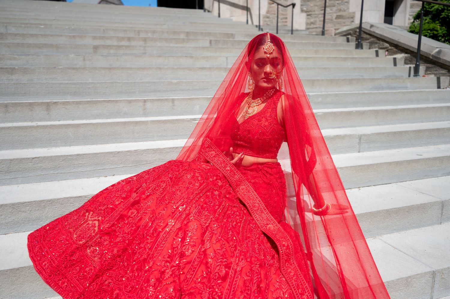 Flowing red dress movement captured in sequence on architectural stone steps.