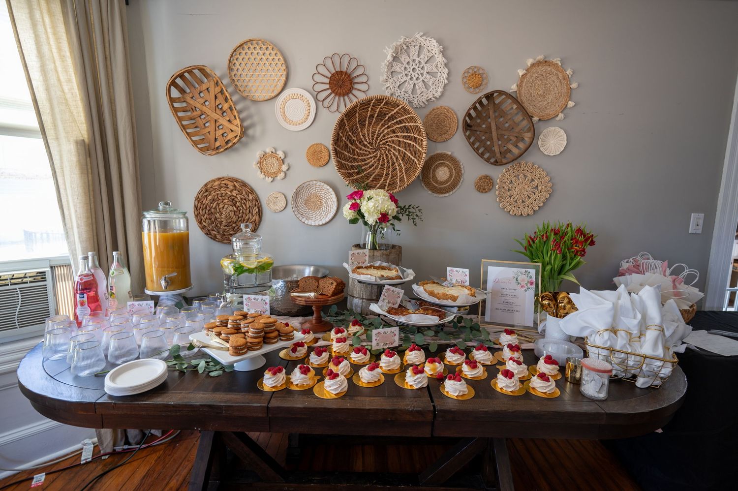 Elegant dessert and beverage station with decorative woven wall art and cupcake display.