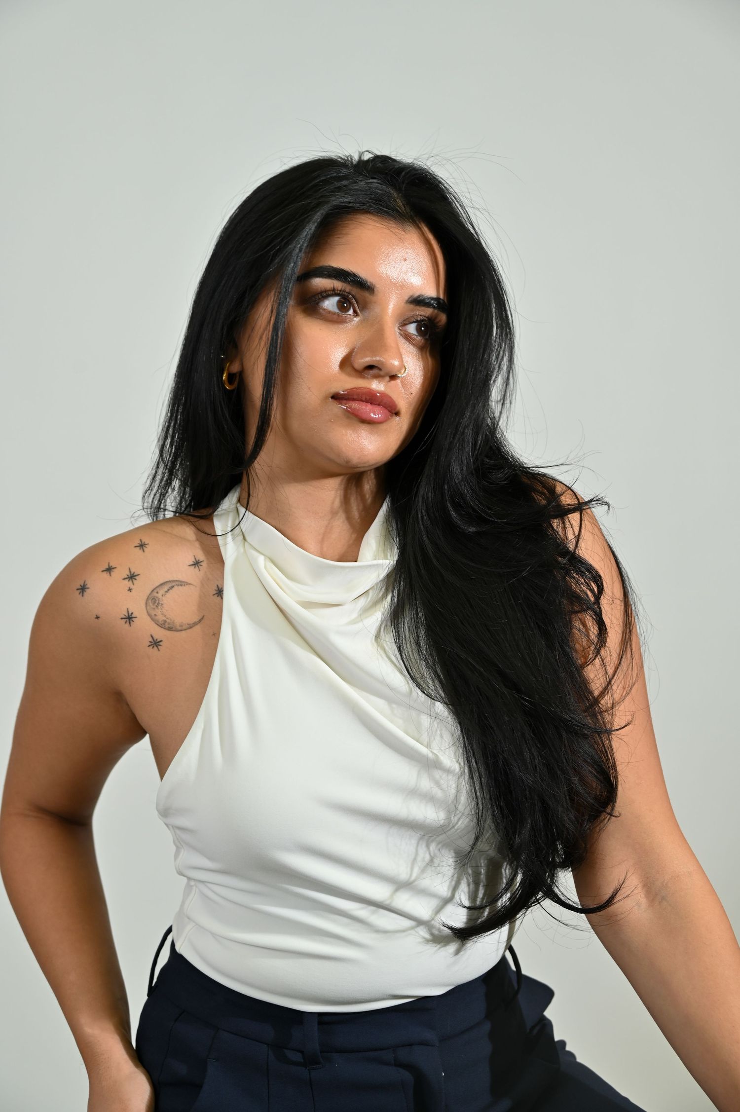 Modern fashion portraits featuring white halter top and navy bottoms against light background.