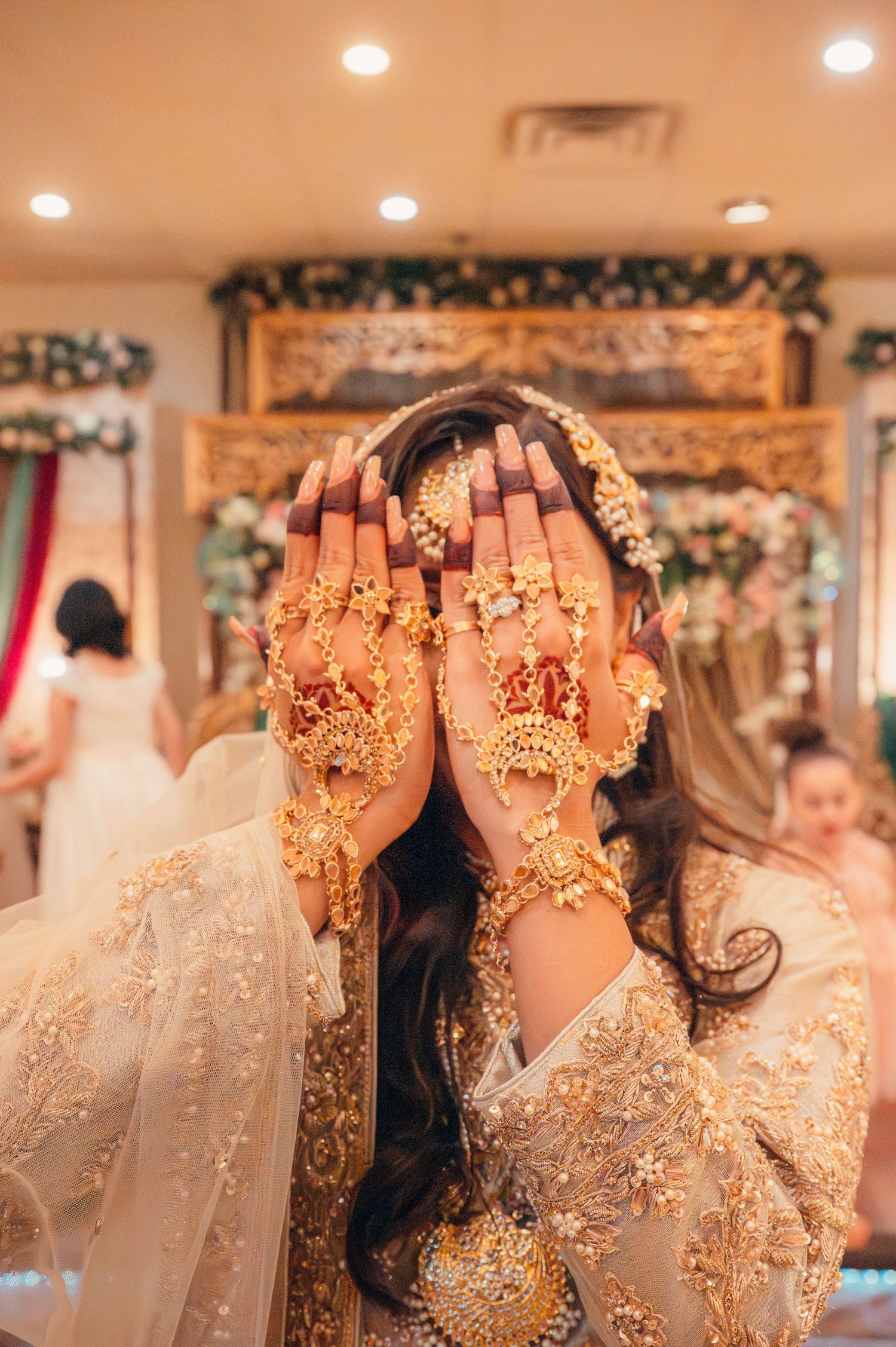 A series of wedding photos showing hands decorated with henna and gold glitter against a backdrop of white lace and decor.