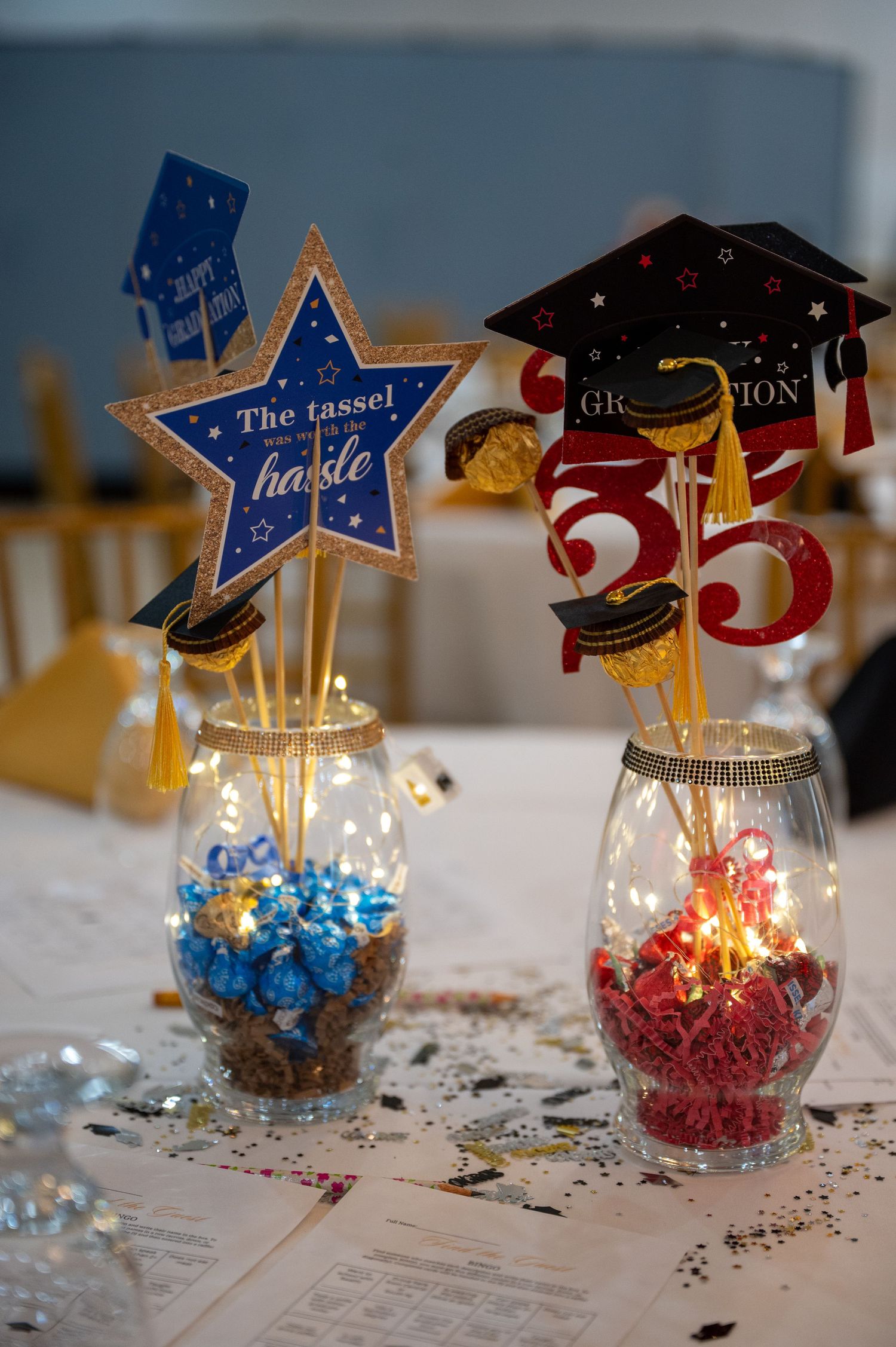 Decorative graduation centerpieces with stars and numbers in glass vessels.