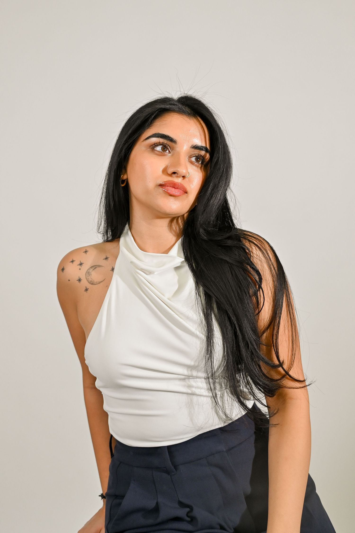 Fashion portraits showcasing white halter top and navy bottoms with celestial tattoo details.
