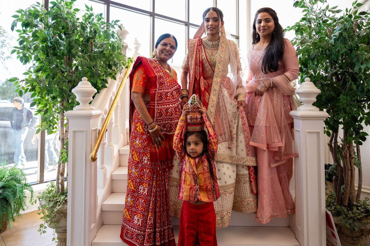 Wedding guests in colorful traditional attire walking through an indoor hallway.