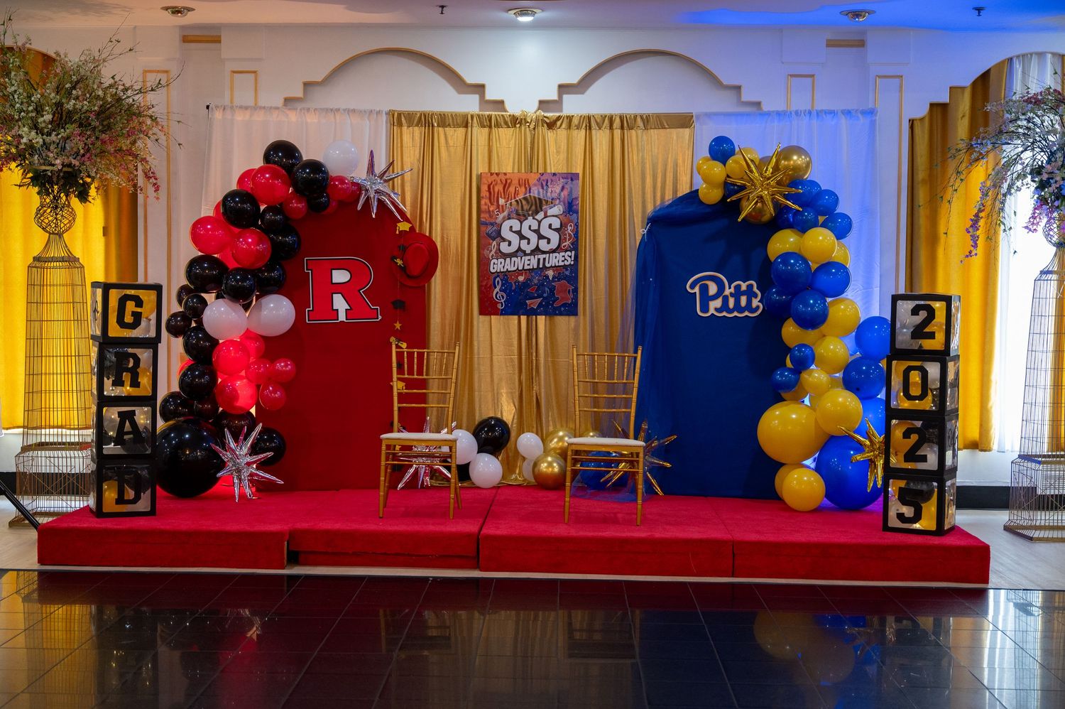 Graduation party venue decorated with red and blue balloon arrangements and banners.