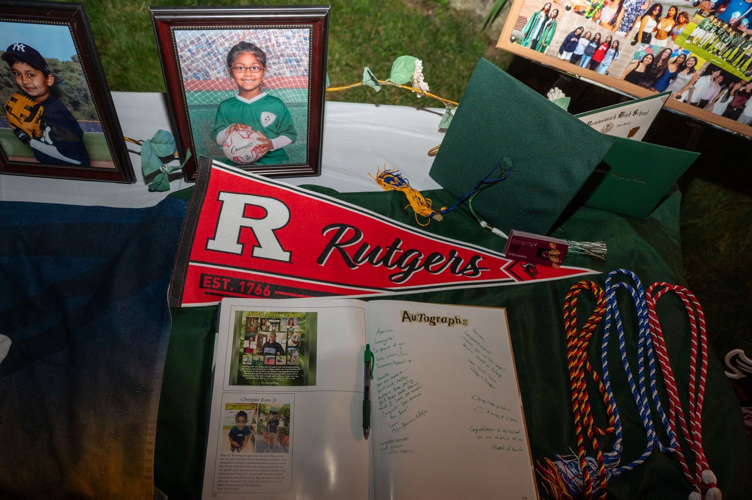 Collection of graduation memorabilia and photo displays on a dark table.