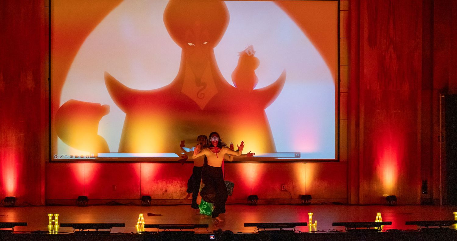 Stage lighting creates warm orange and red ambient glow during performance.