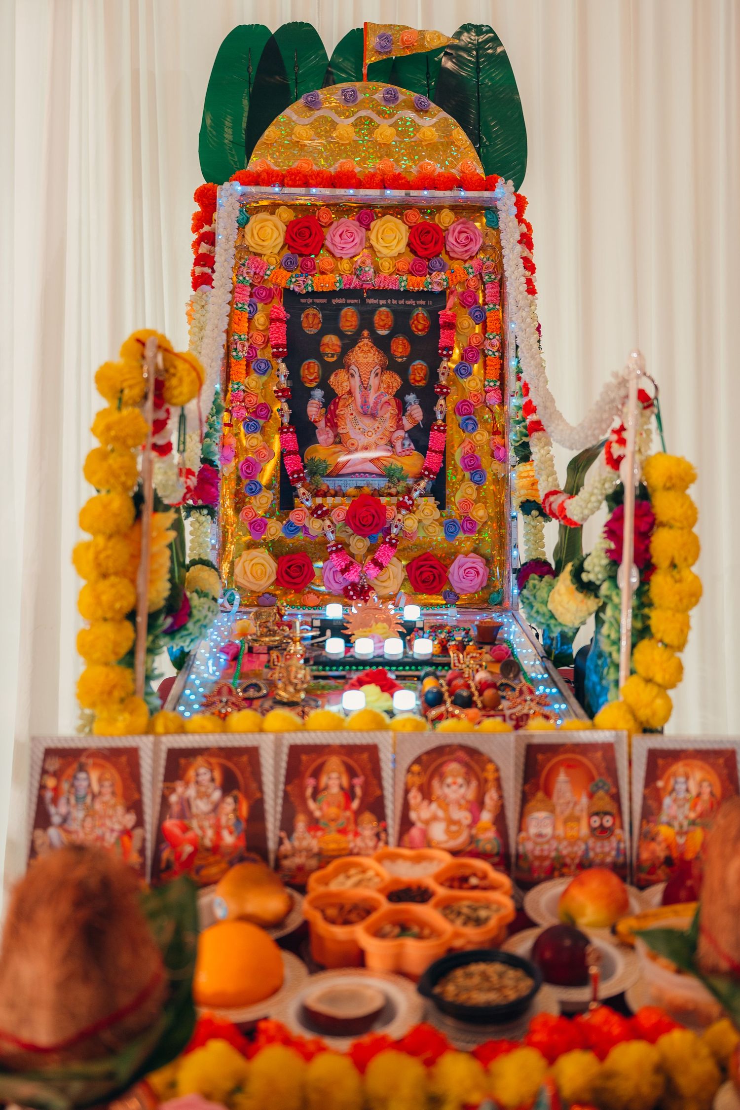 Colorful Hindu altar display with marigold garlands and decorative items for a wedding ceremony.