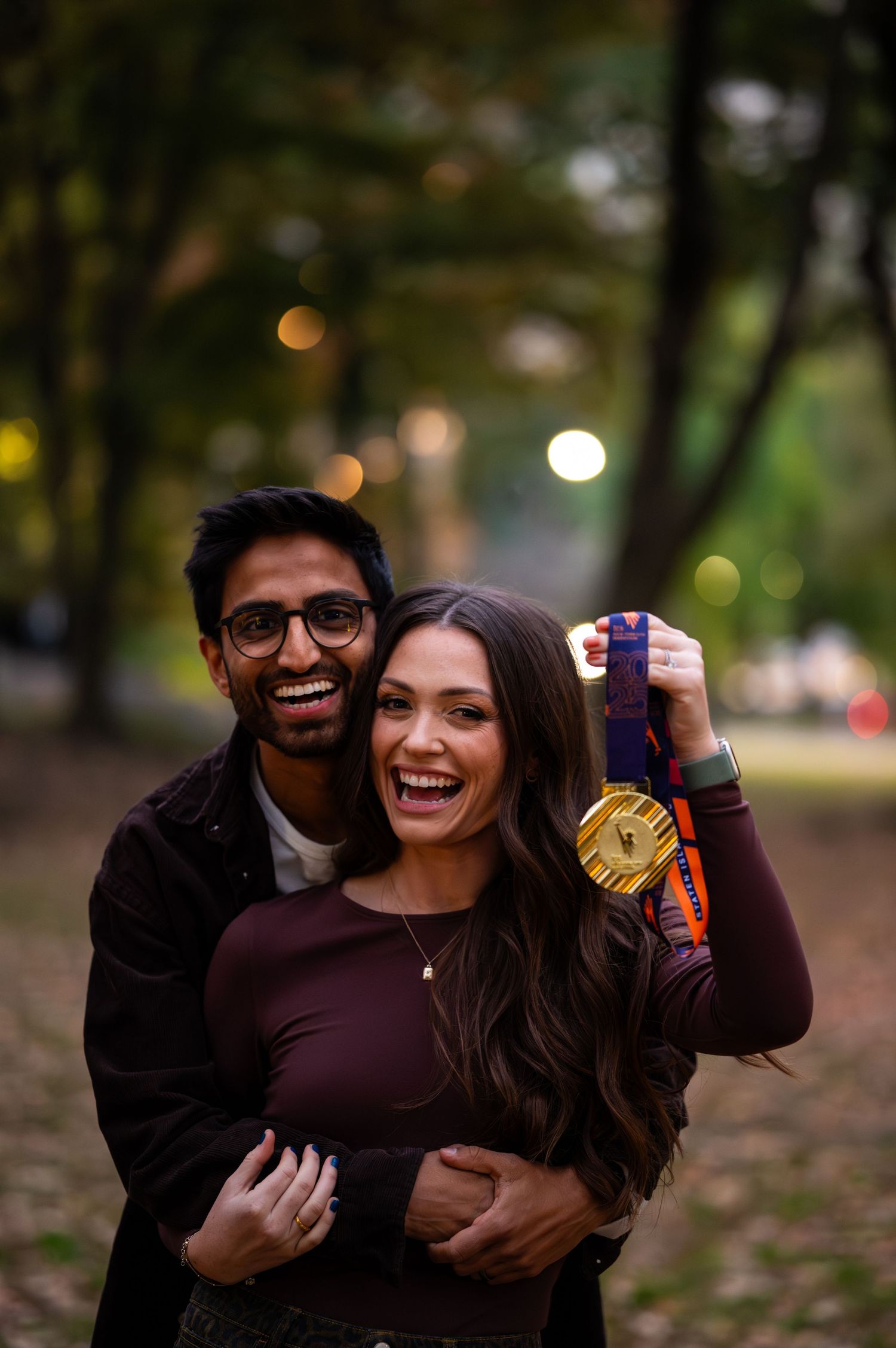 Candid autumn engagement photos showing playful moments in a park setting.