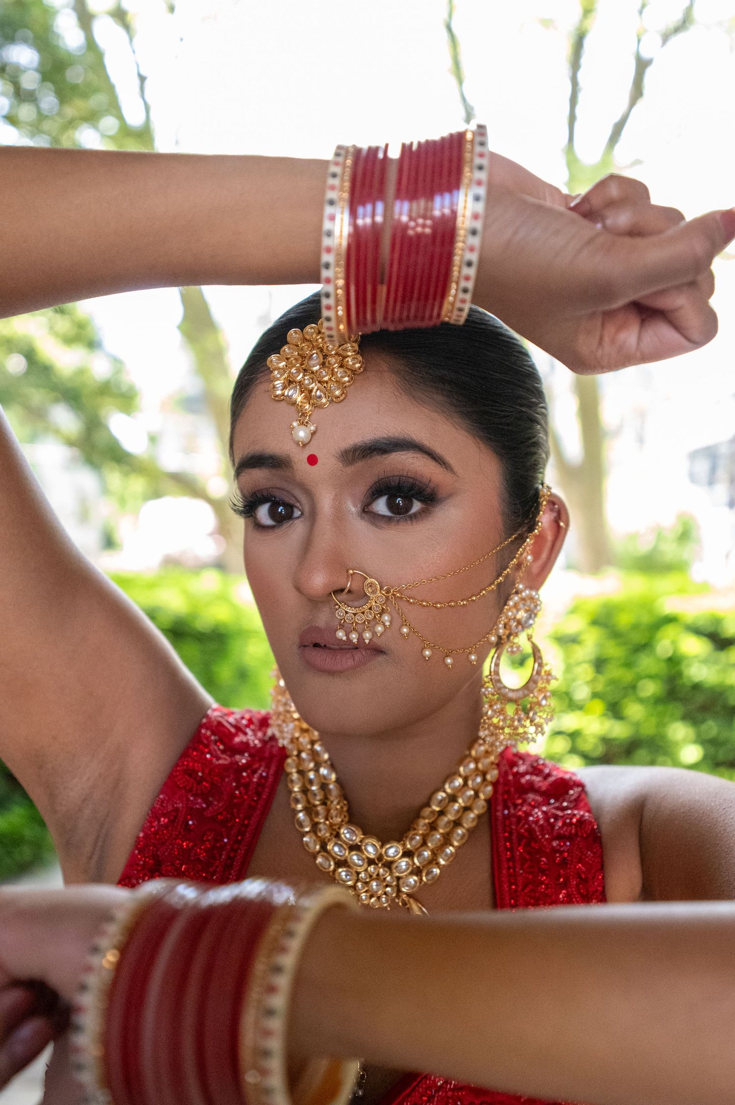 Traditional South Asian bridal jewelry and makeup details with gold accents.