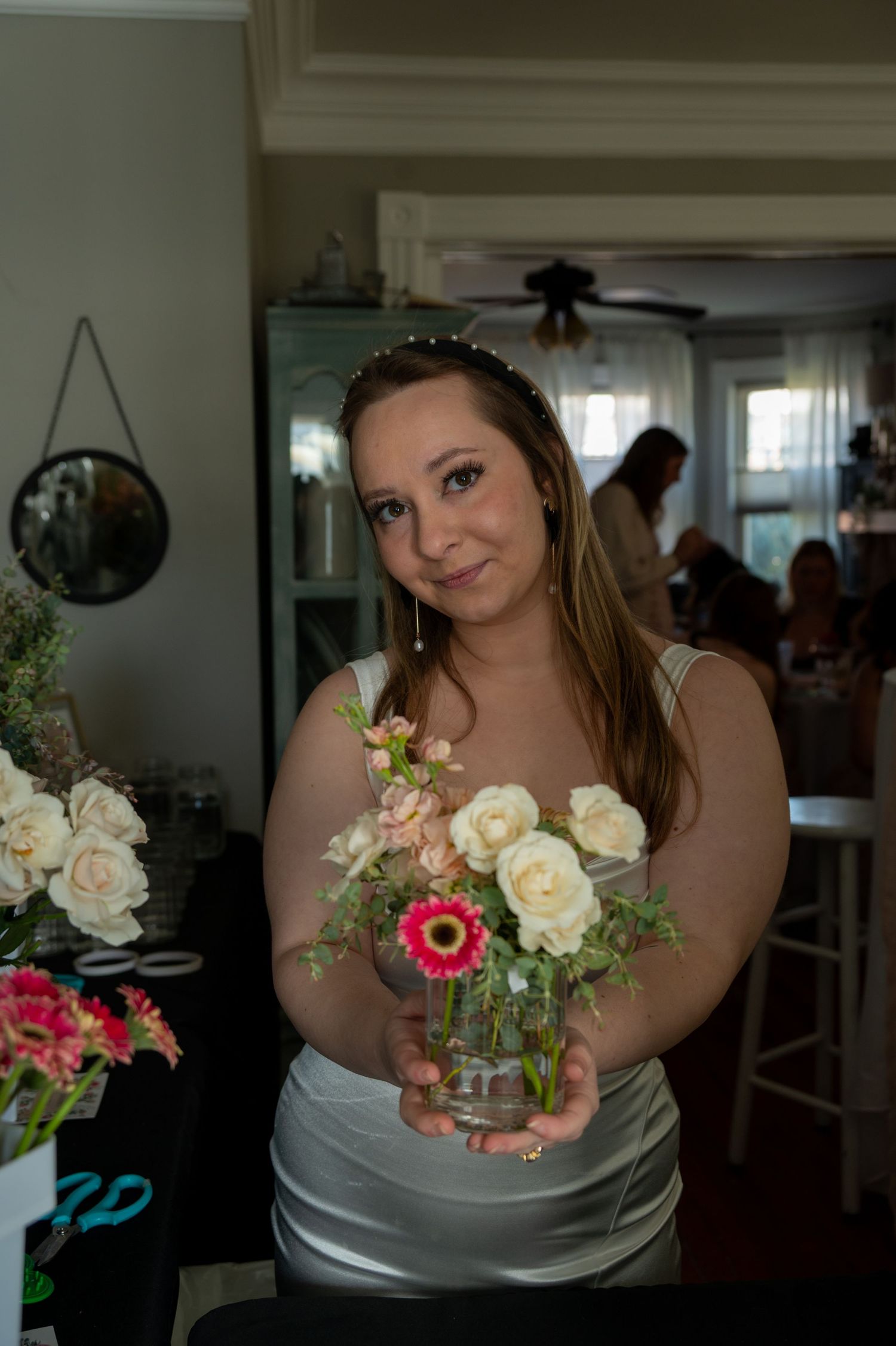 Small floral arrangements in glass vases featuring pink and white roses.