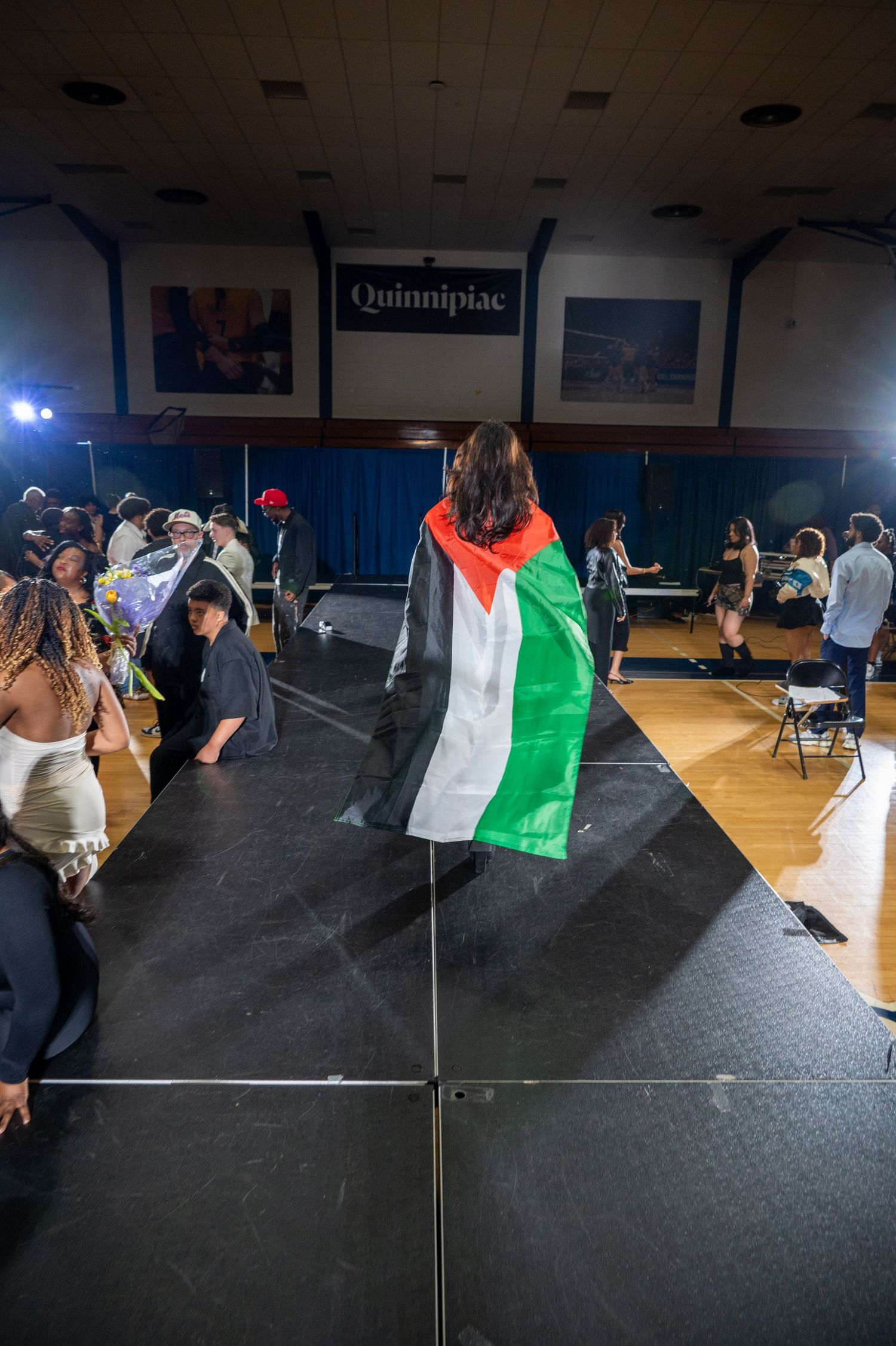 Stage performers wave flags and banners during an expressive dance performance.
