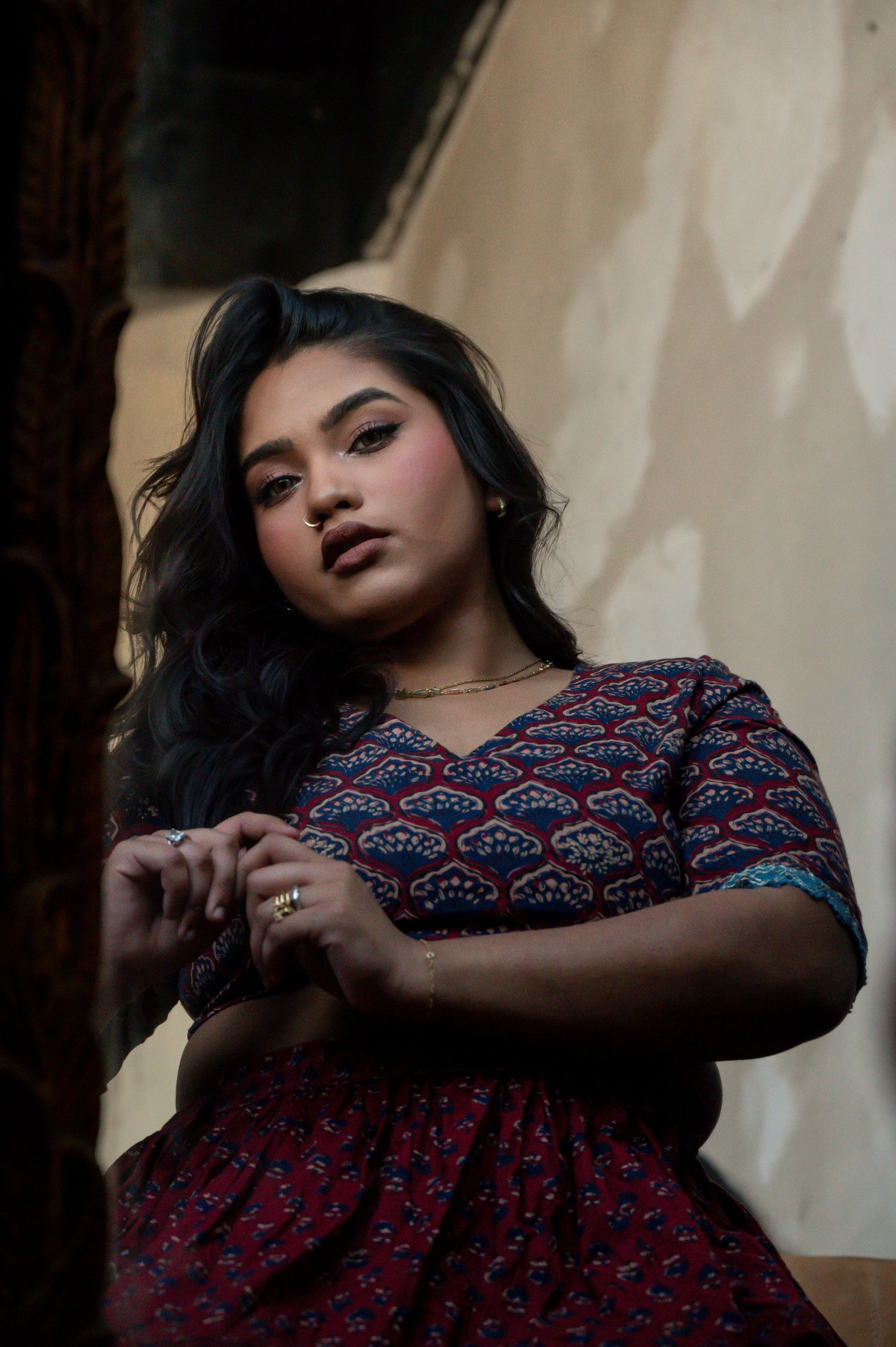Moody portrait series featuring a patterned dress against white curtains in dramatic lighting.