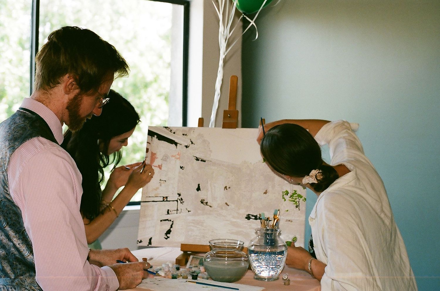 People sitting at a table collaborate together examining documents and materials during a business workshop.