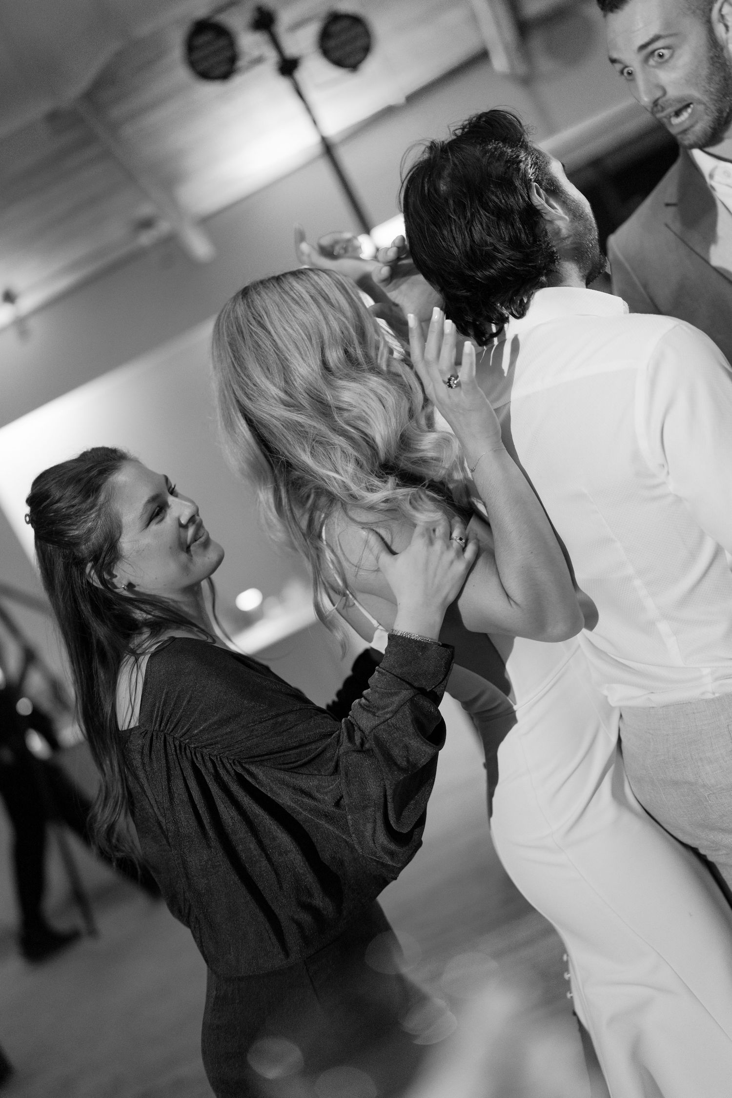 Black and white photos capturing energetic dancing at a wedding reception.
