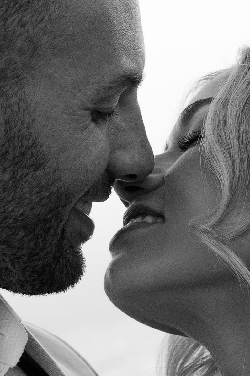 Intimate black and white close-up of romantic kiss between couple.