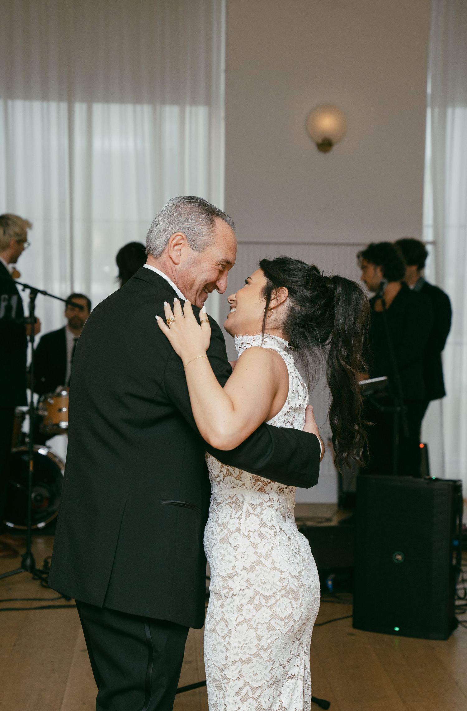 Couple sharing their first dance in an elegantly decorated wedding reception hall.