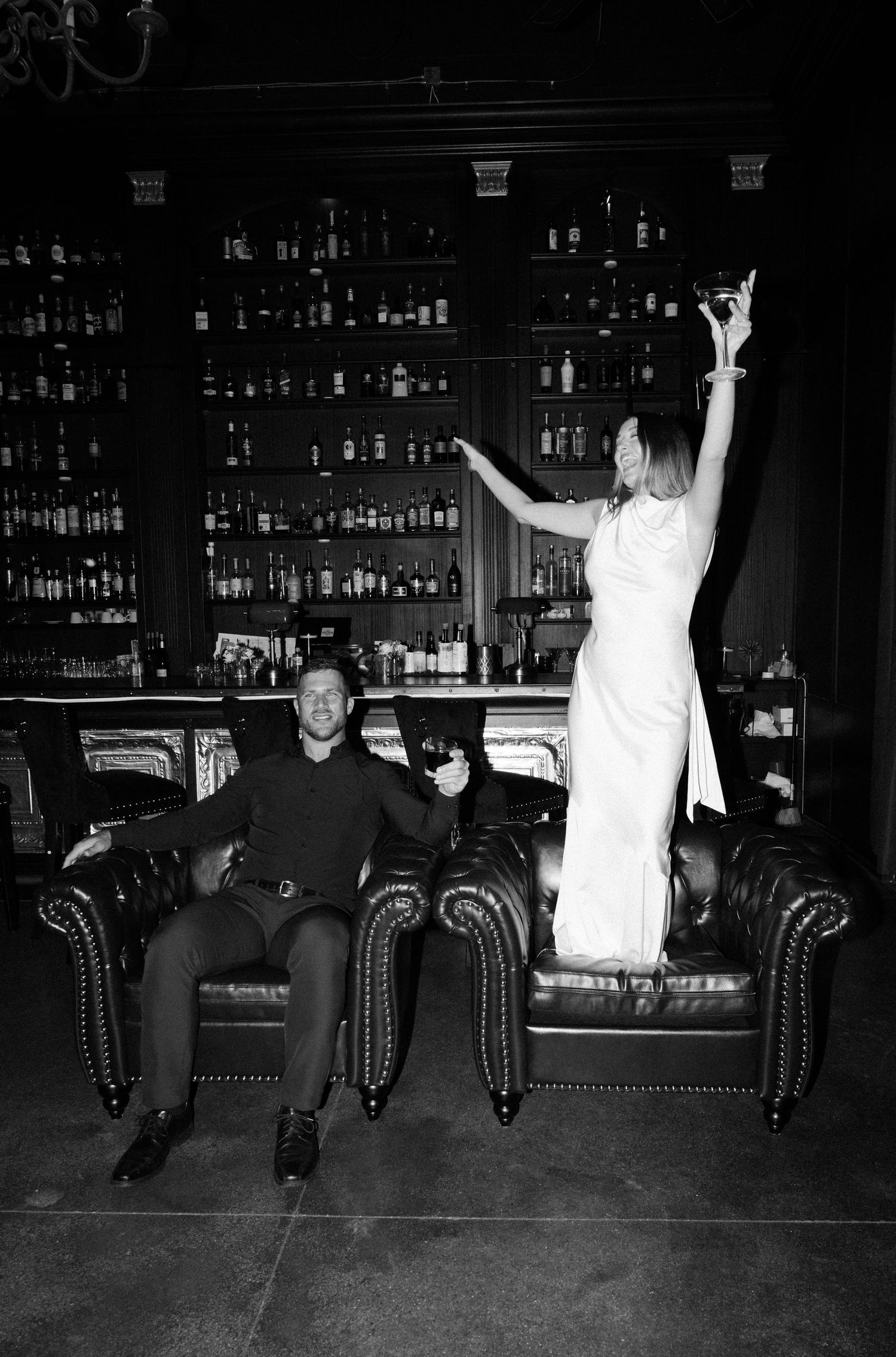 A sequence of black and white photos showing two people sitting on a couch in what appears to be a bar or lounge setting.