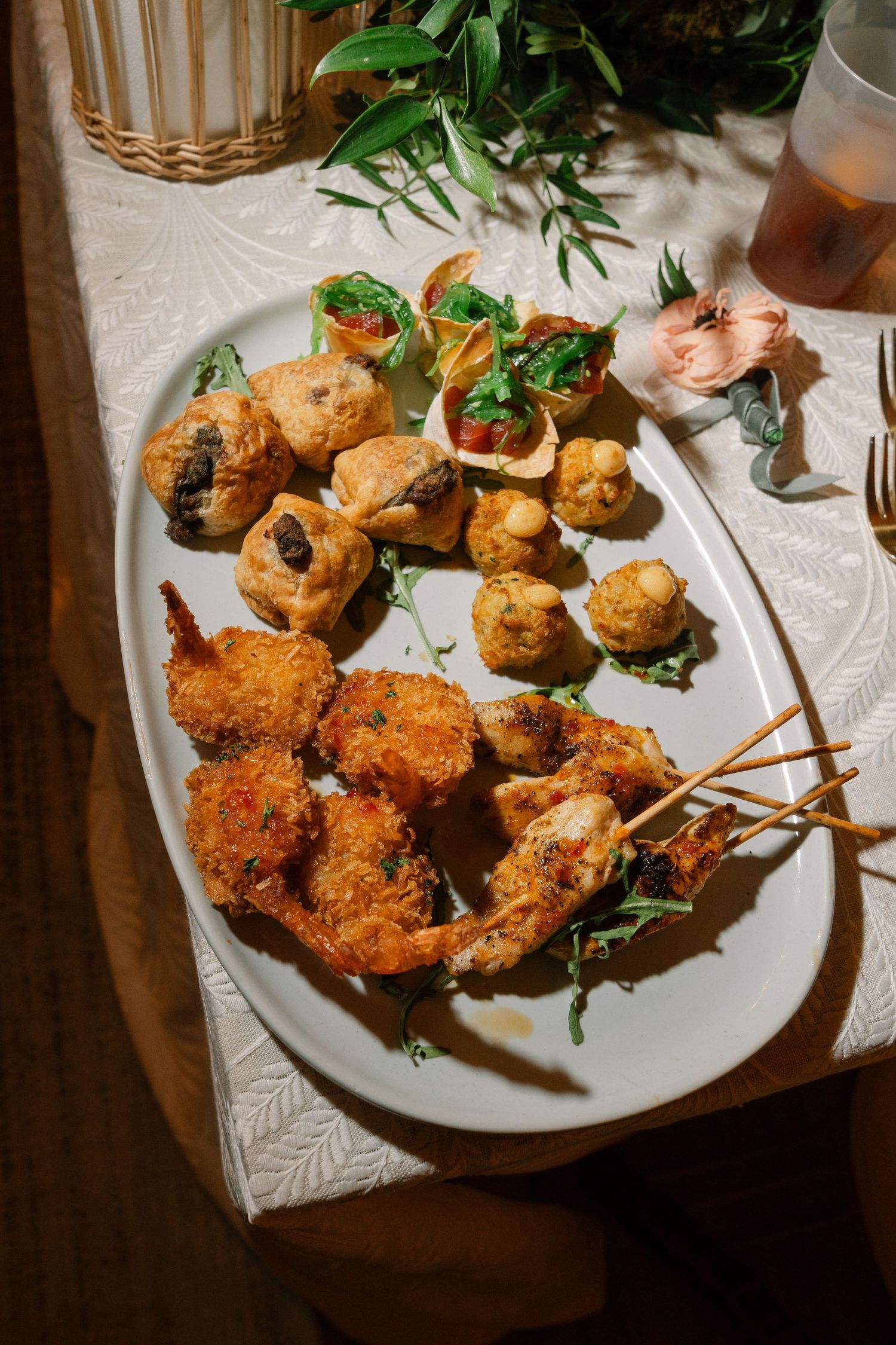 Gourmet seafood platter with fried shrimp and appetizers served on white tablecloth.