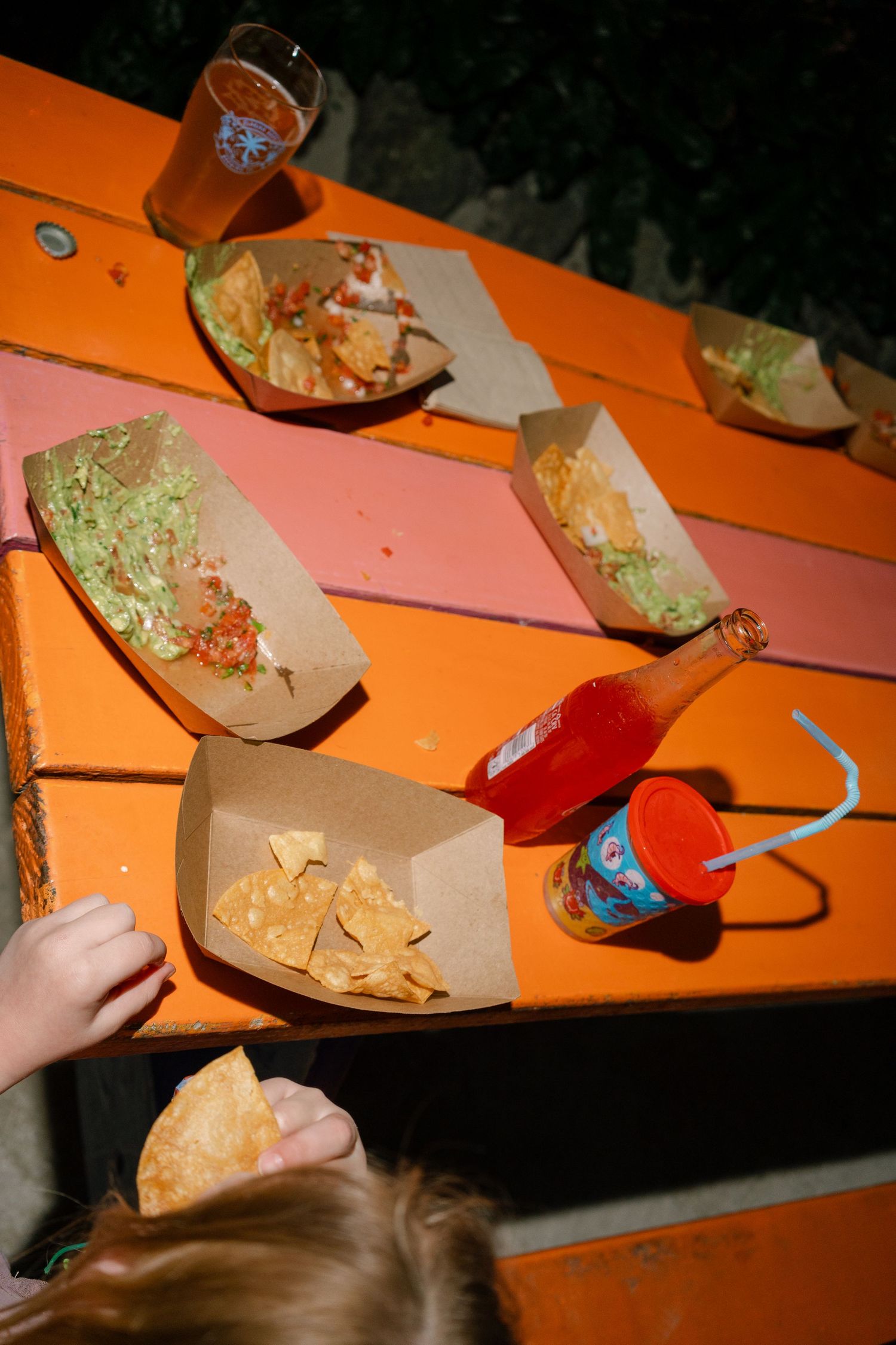 Close-up view of hands cutting or preparing food on an orange surface.